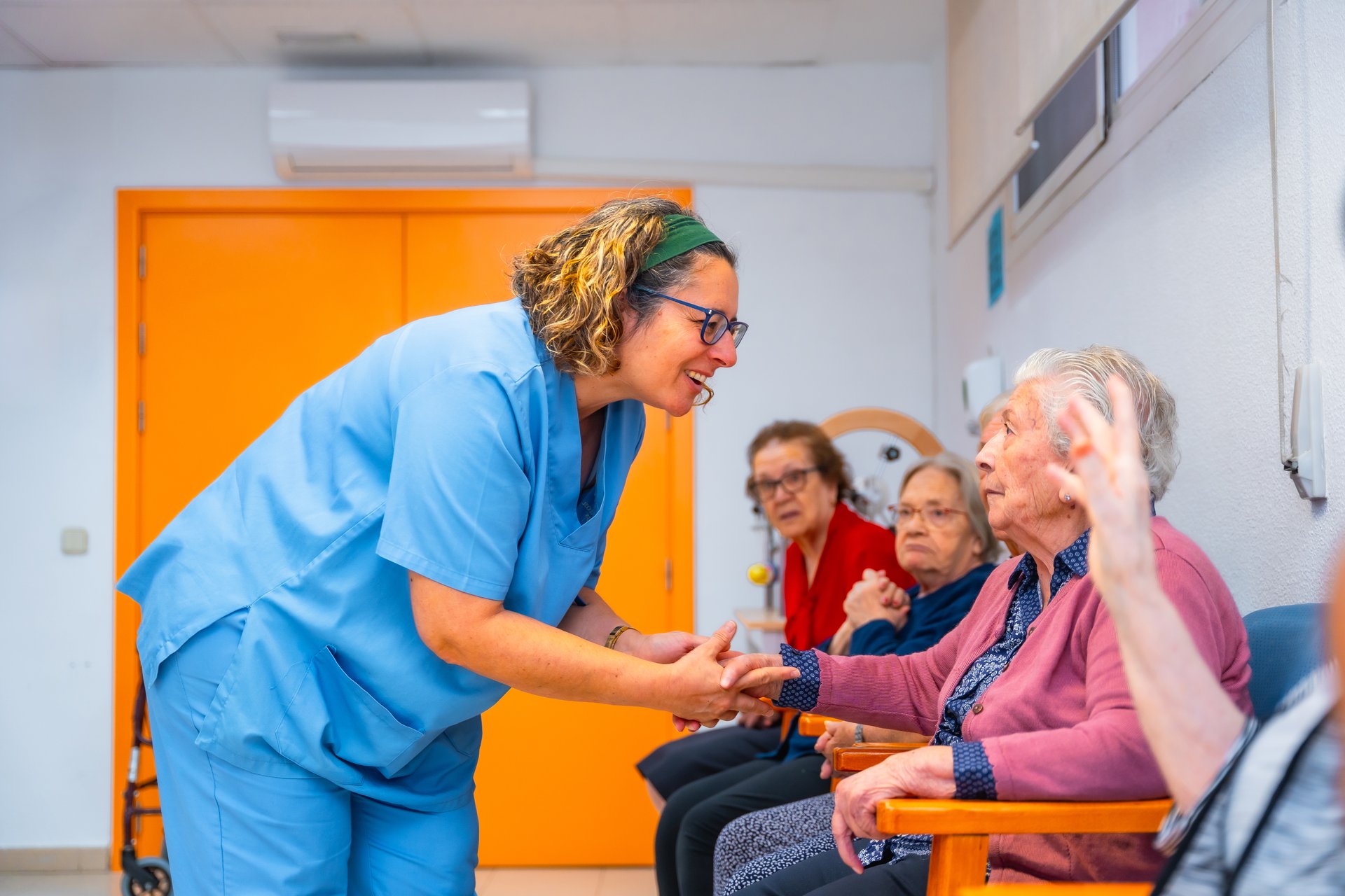 Nurse holding hand of senior woman in the rehab center of geriatrics