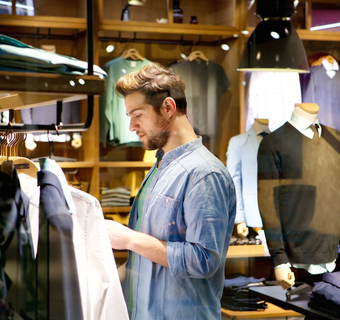 Portrait of a handsome young man shopping for clothes at shop
