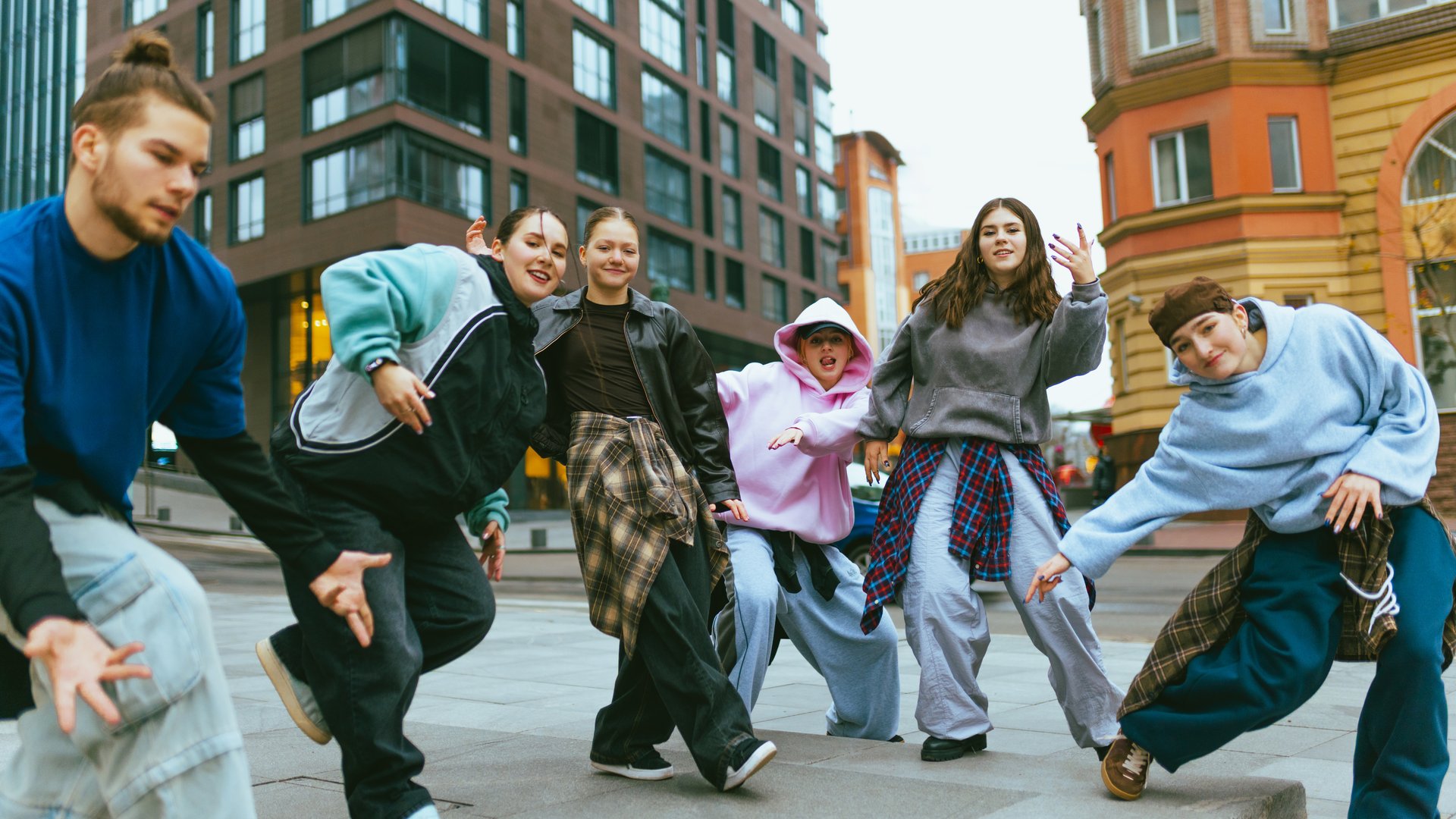 Young hip hop dancers performing on city street. Concept of joyful urban lifestyle, street fashion, freedom, teamwork for music ads, events, social media and branding.