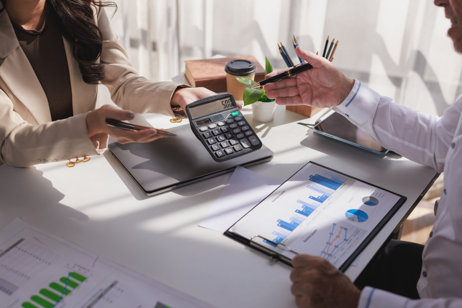 Business colleagues calculating finances and discussing market data, working on taxes and budgeting