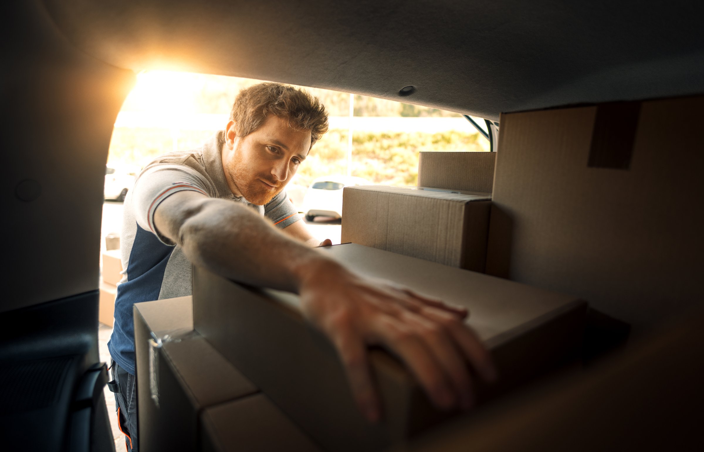 Professional delivery man loading packages into a van, express delivery service