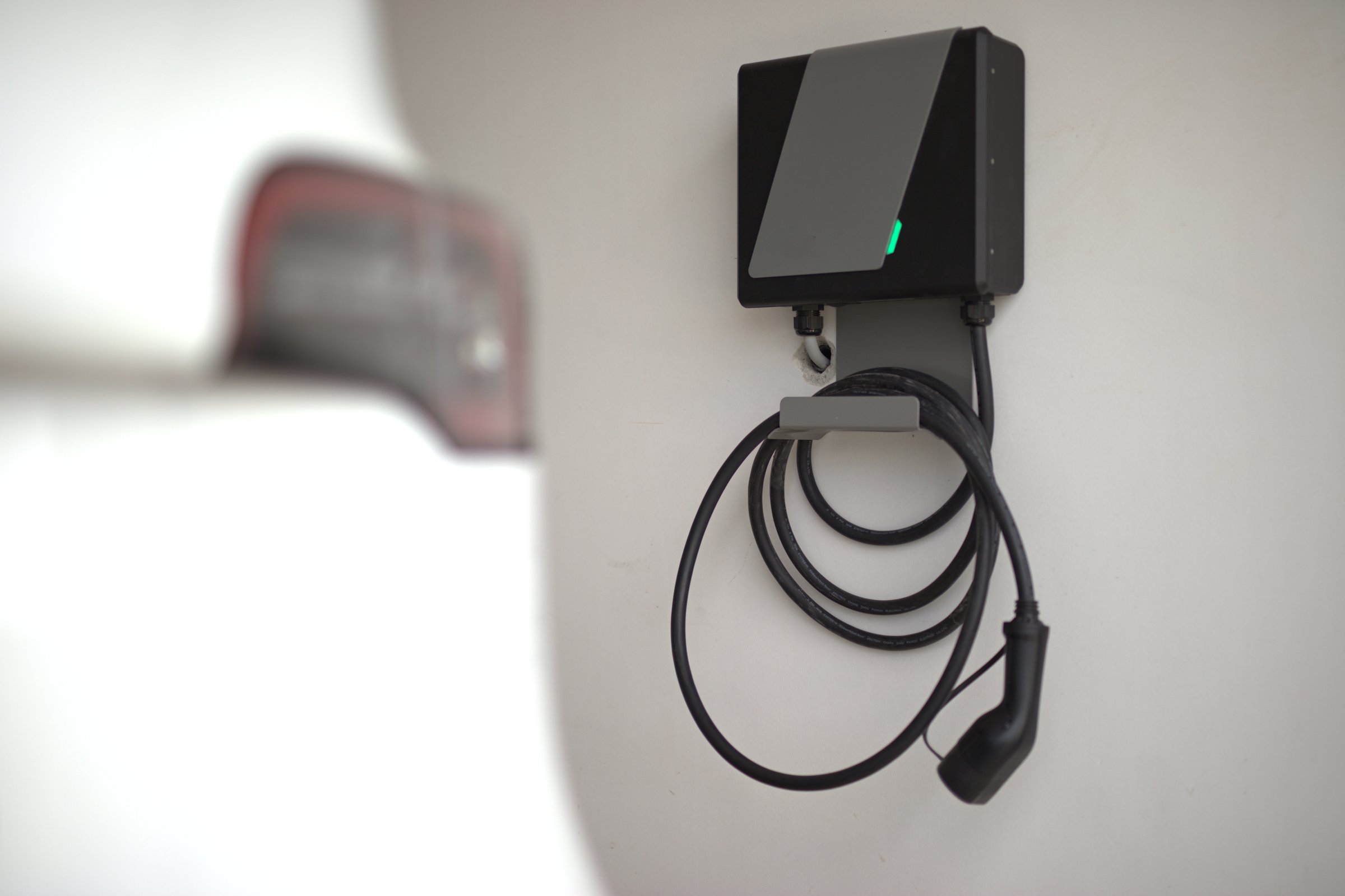 Electric car and electric car charger installed in the private garage at home.