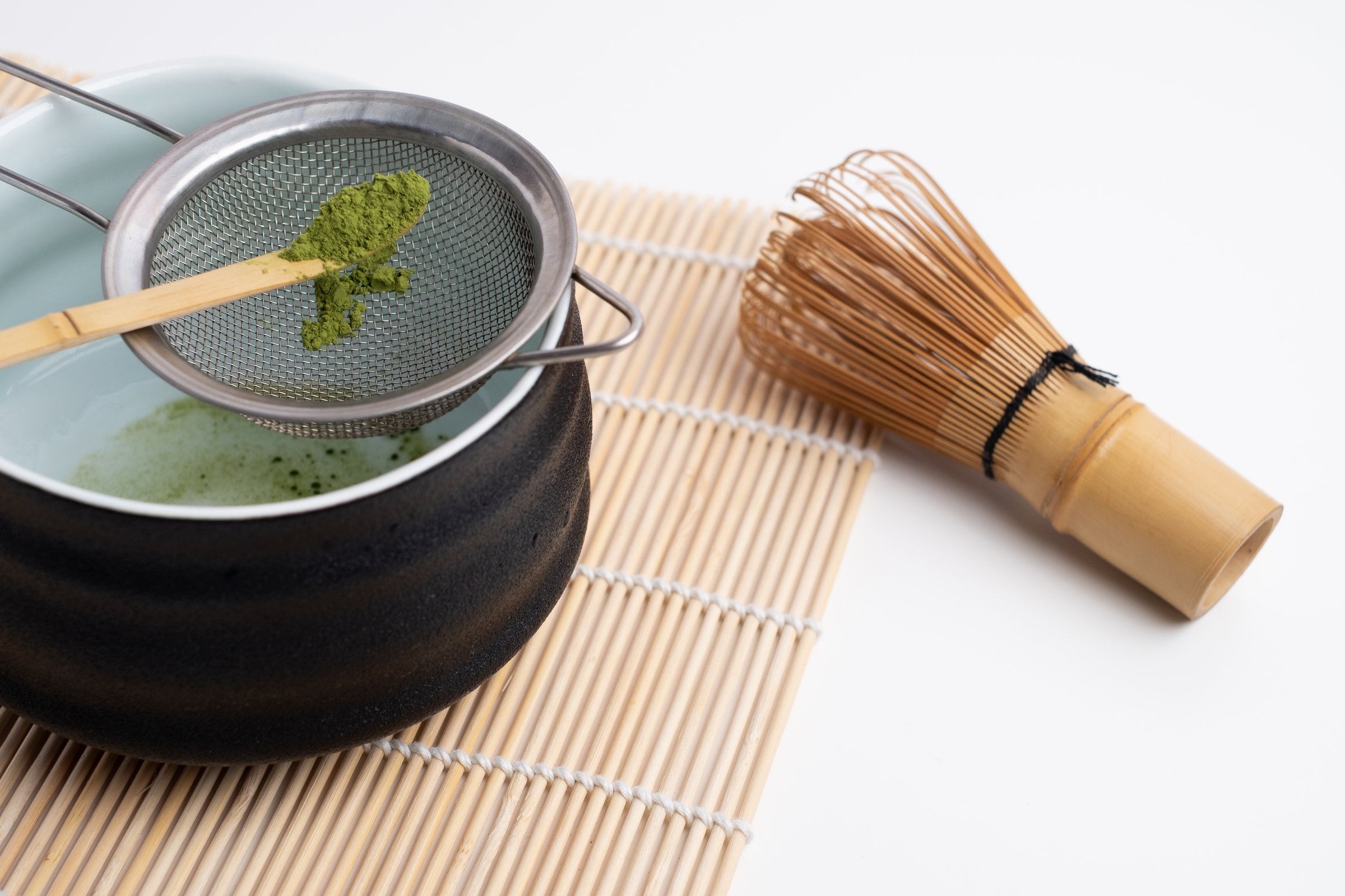 Green matcha close-up. Chasen, bamboo whisk. Traditional tools for making matcha. Matcha powder. Making matcha, recipe.