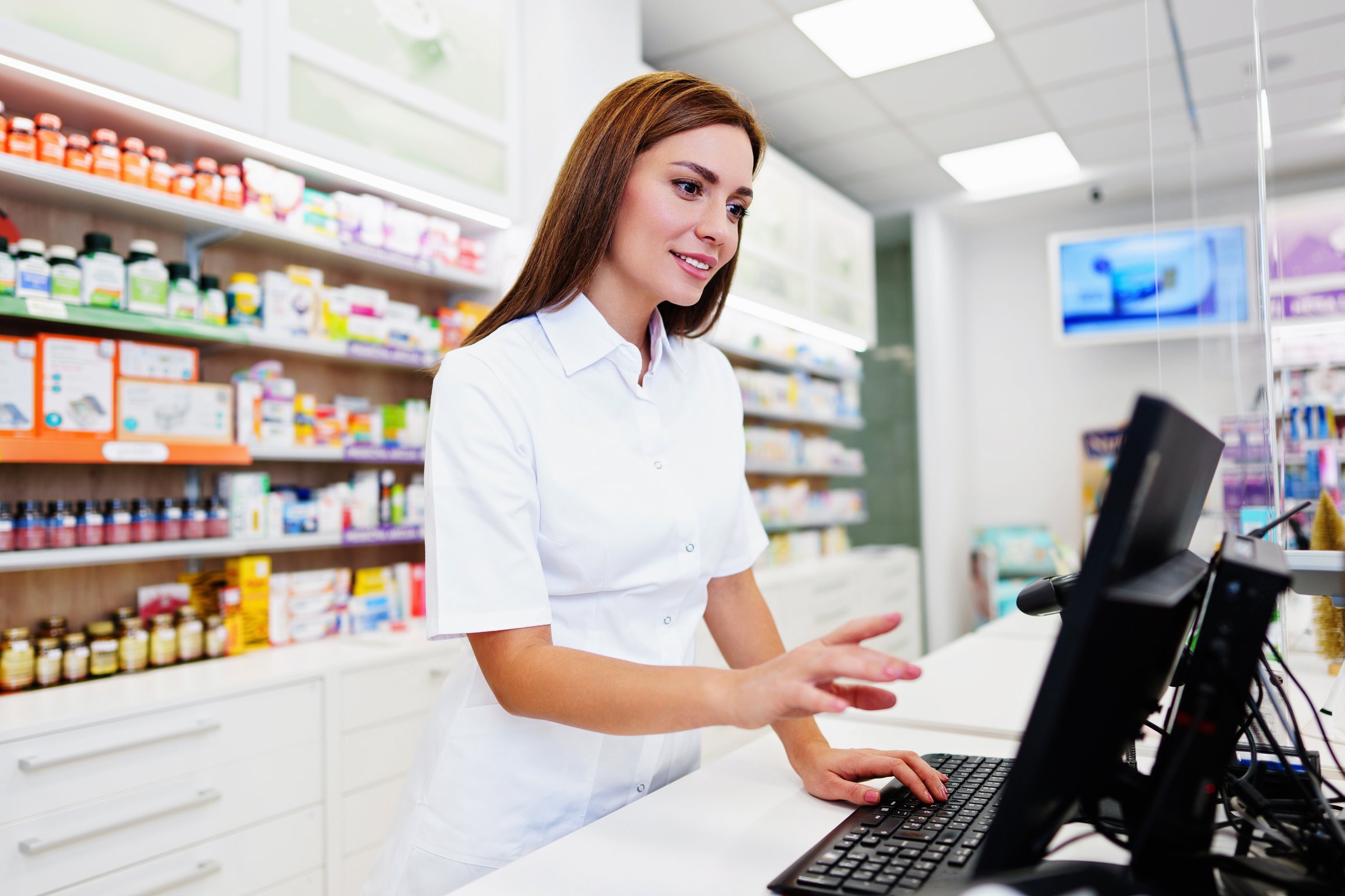 Beautiful pharmacist working in a drug store and doing a stock take. Portrait of a positive healthcare worker or a chemist at his work.