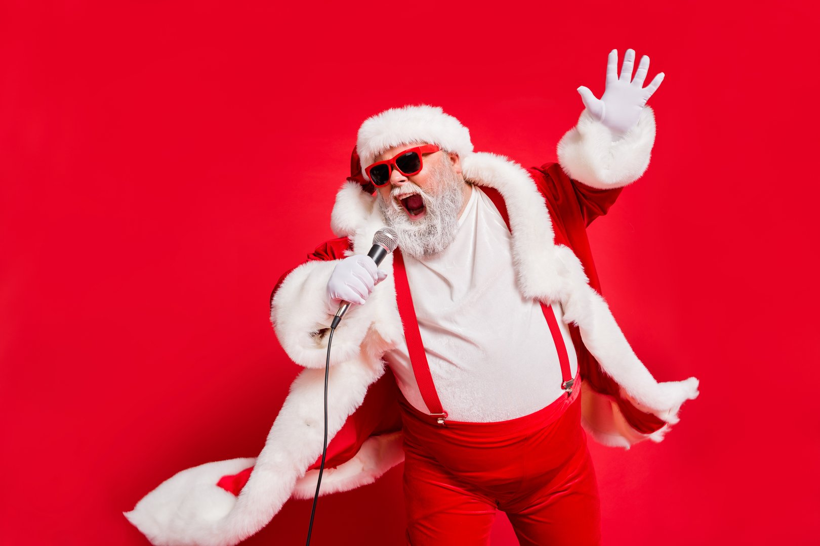 Closeup photo of funny funky wild vocalist screaming in microphone, wearing fur coat gloves suspenders isolated bright background