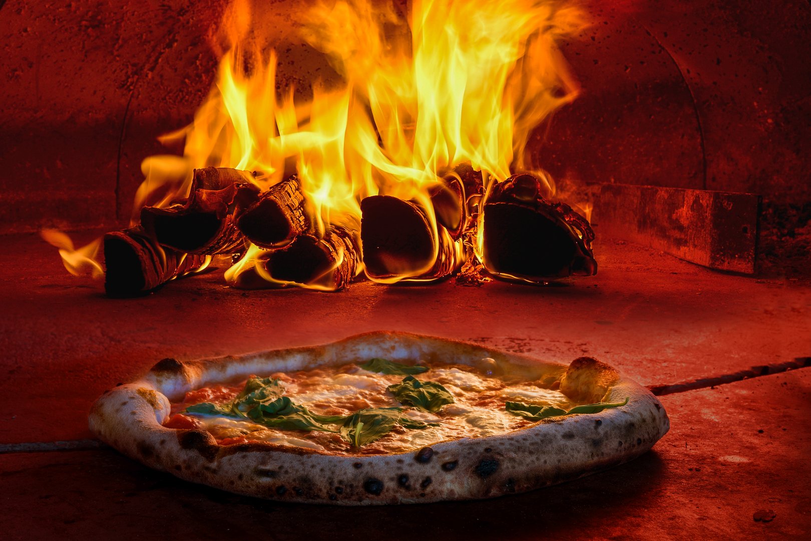 Italian wood fired traditional pizza oven fire crispy tomato cheese basil very hot fresh inside dish