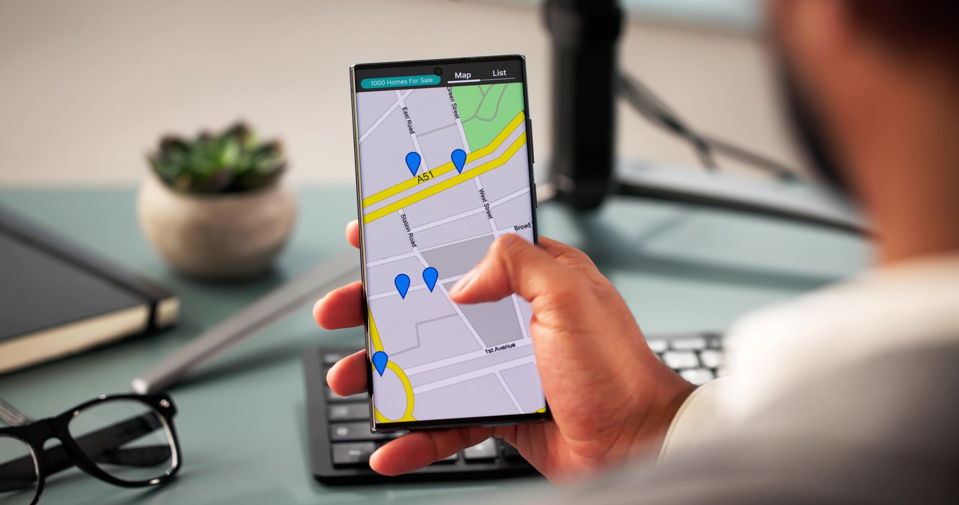 Young man using smartphone to search for real estate properties online.