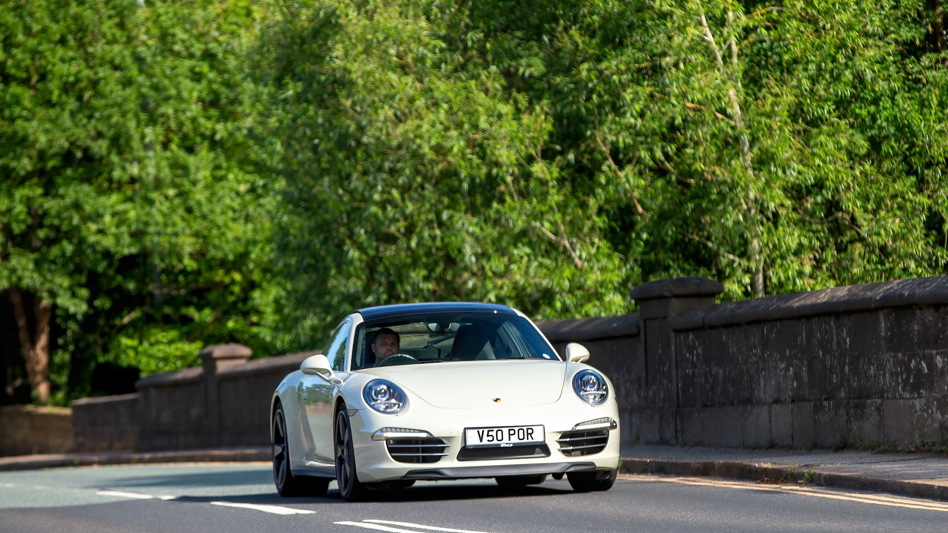 Milton Keynes,Bucks,UK - June 1st 2025:  2014 white Porsche 911 car driving on a British road