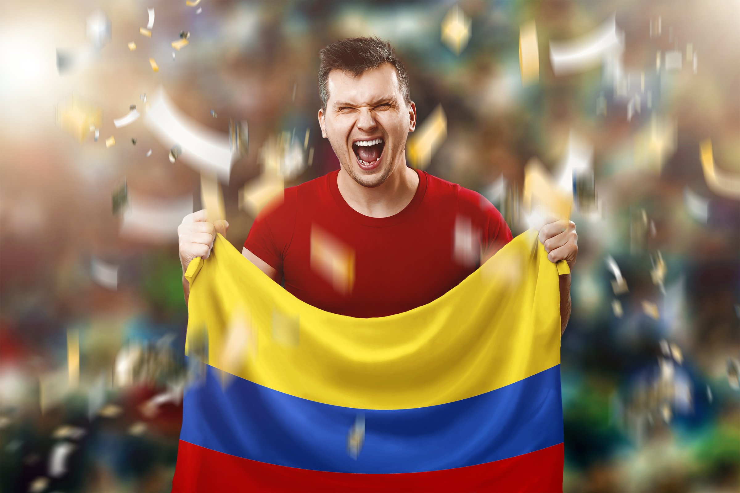 A Colombian fan, a fan of a man holding a Colombian national flag in his hands. Soccer fan in the stadium.