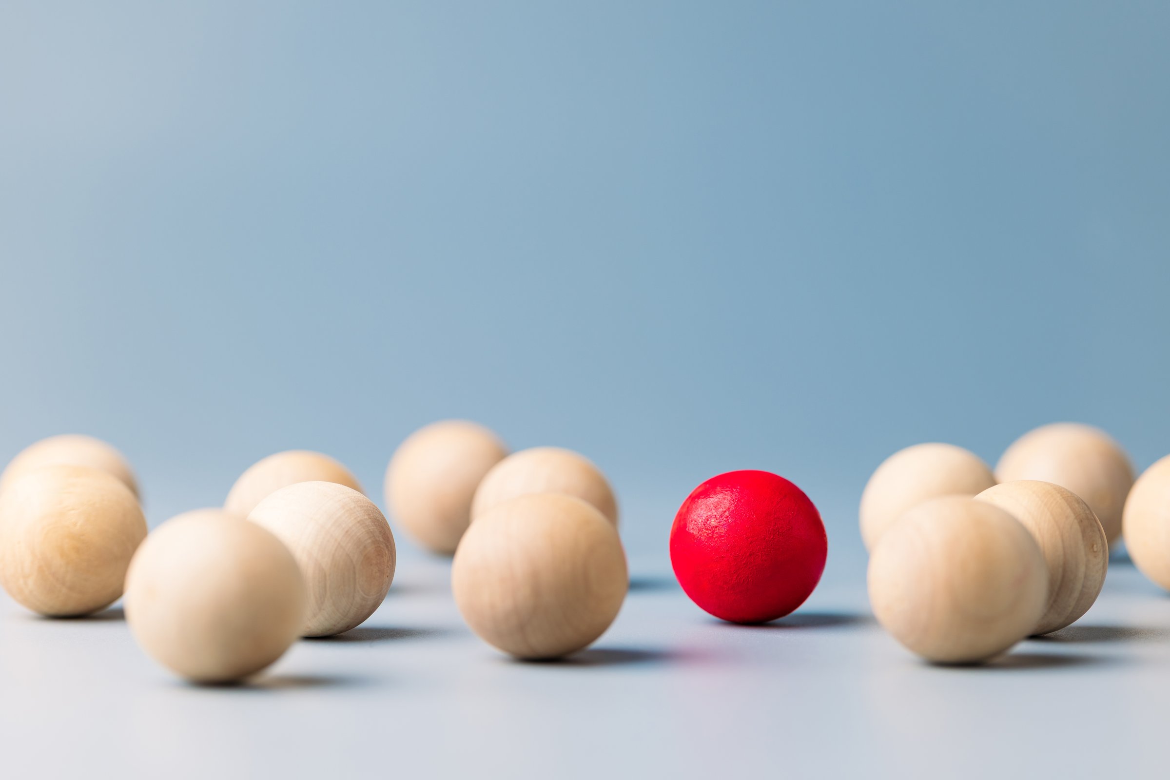 Unique red ball in the group of wooden red balls, being different concept, noticable in the crowd
