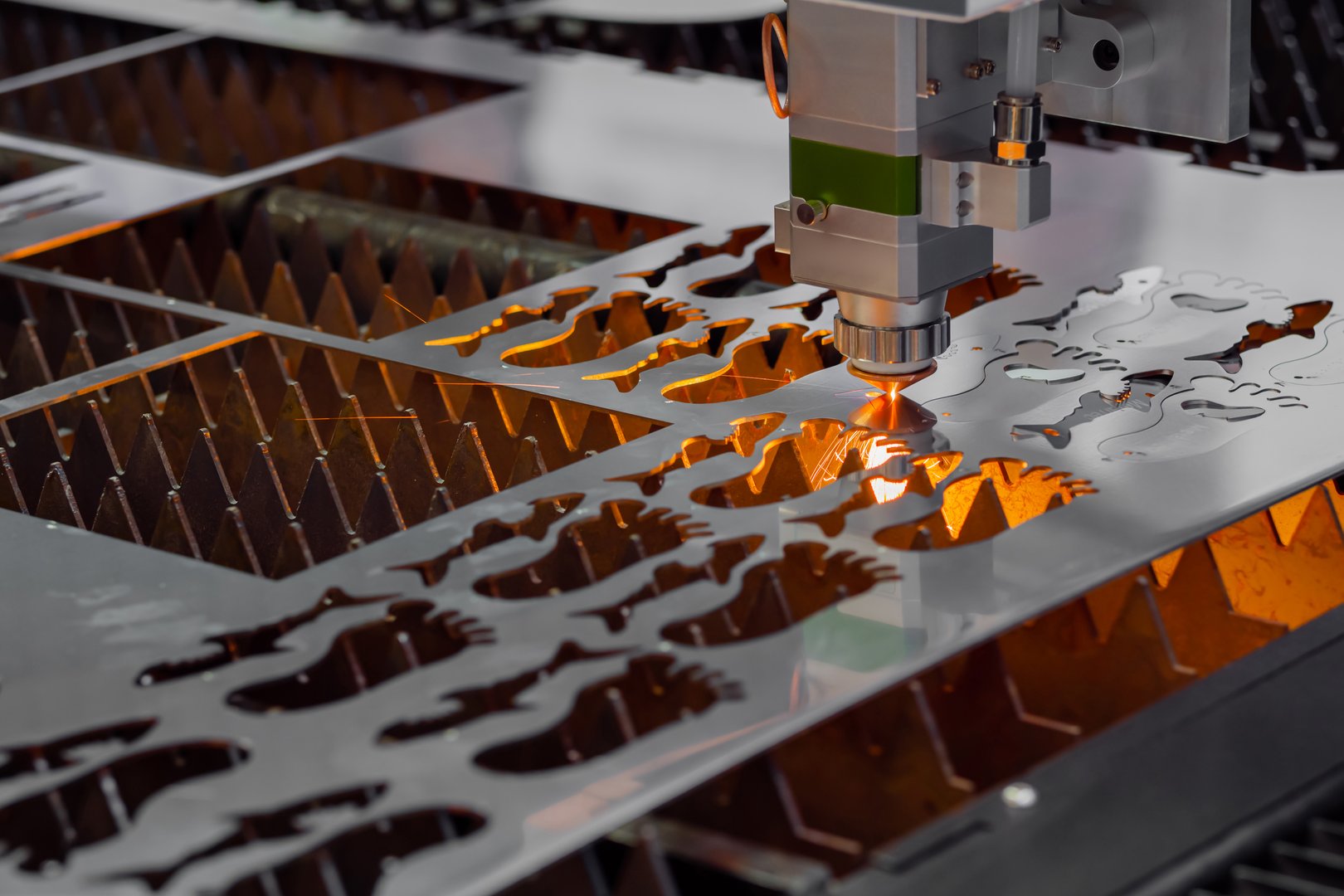 Automatic cnc laser cutting machine working with sheet metal with many sparks at factory, plant. Metalworking, technology, industrial, manufacturing and equipment concept