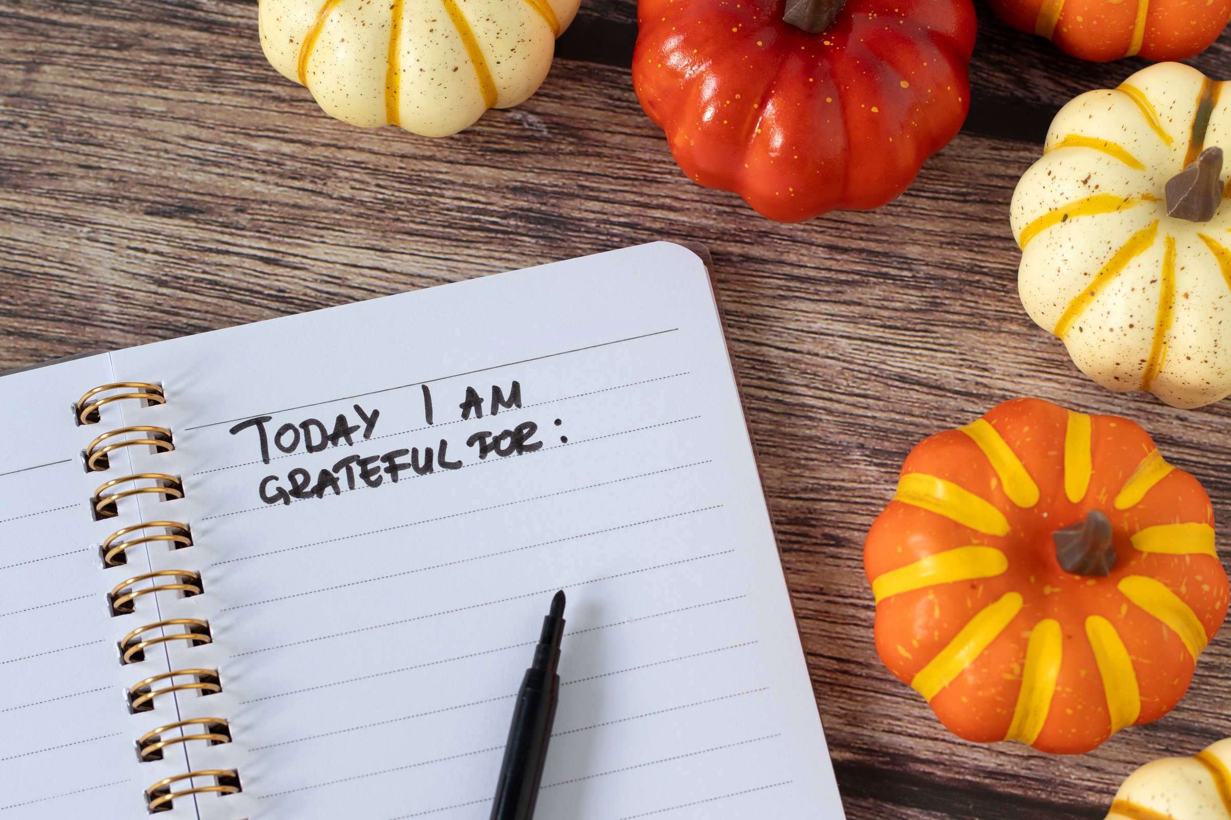 Handwritten text Today I am grateful for in notebook with pumpkins