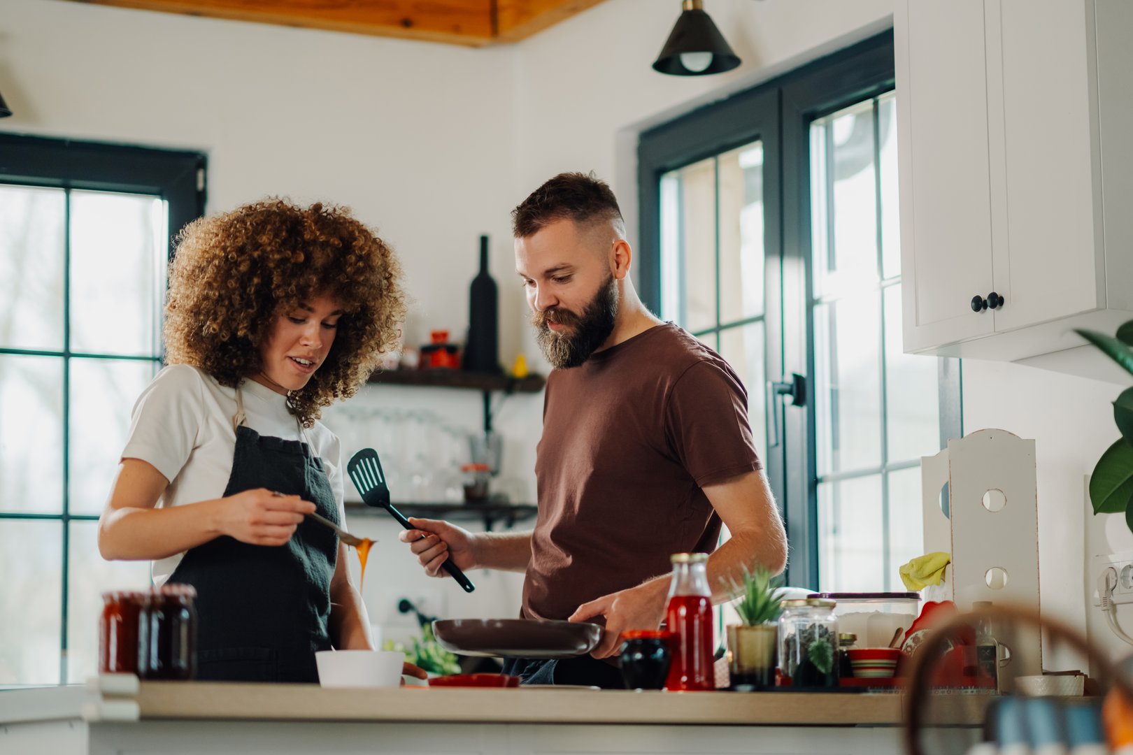 Couple joyfully cooks together in a modern kitchen