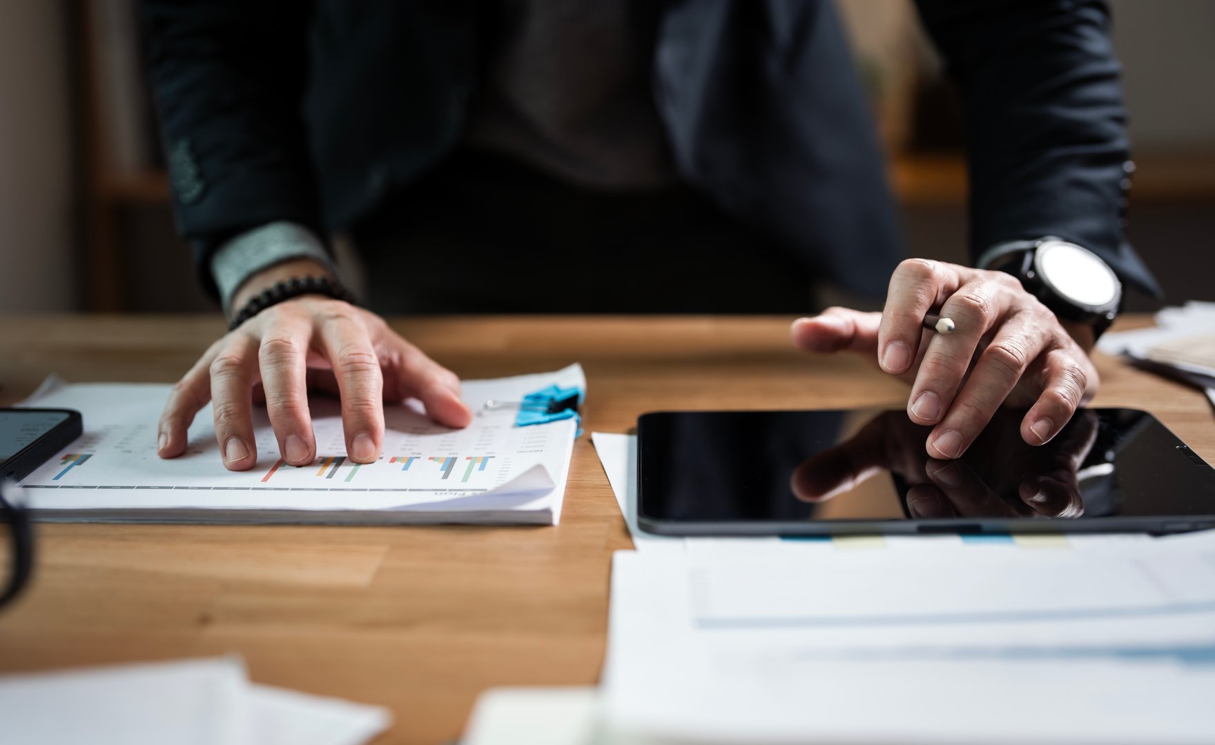 Business analyst using digital tablet analyzing financial statement,  Businessman working with business documents at office. accounting and finance