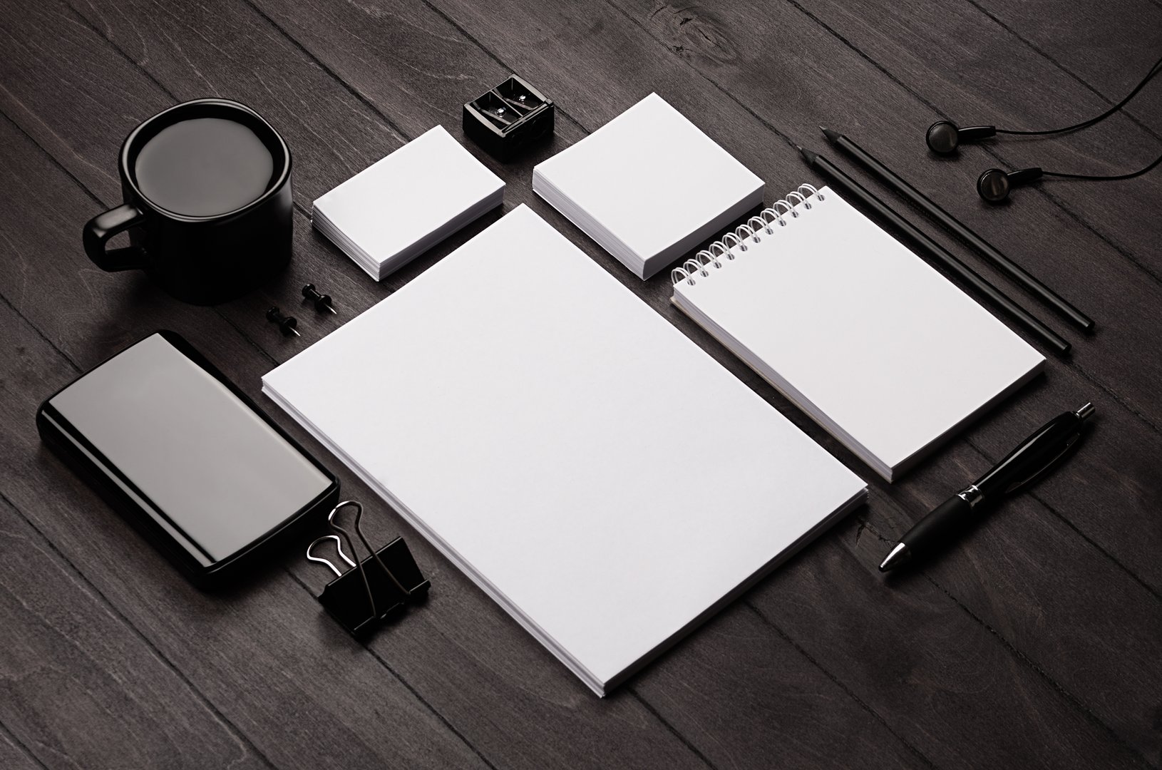 Corporate identity template,  blank stationery set with coffee and earphone on black stylish wood background. Mock up for branding, business presentations and portfolios.
