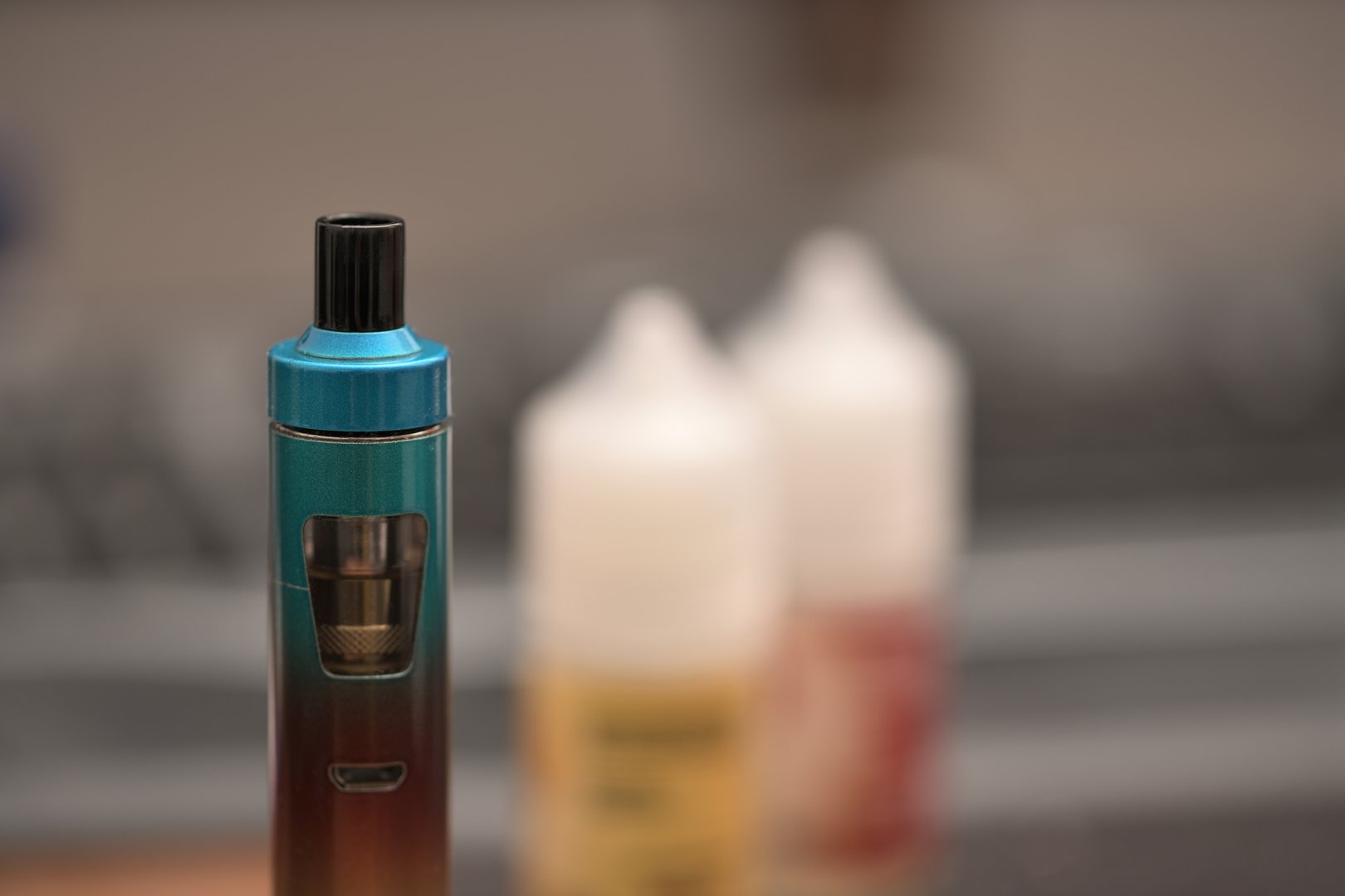 Extreme macro photography of electric cigarette with e-liquid in background