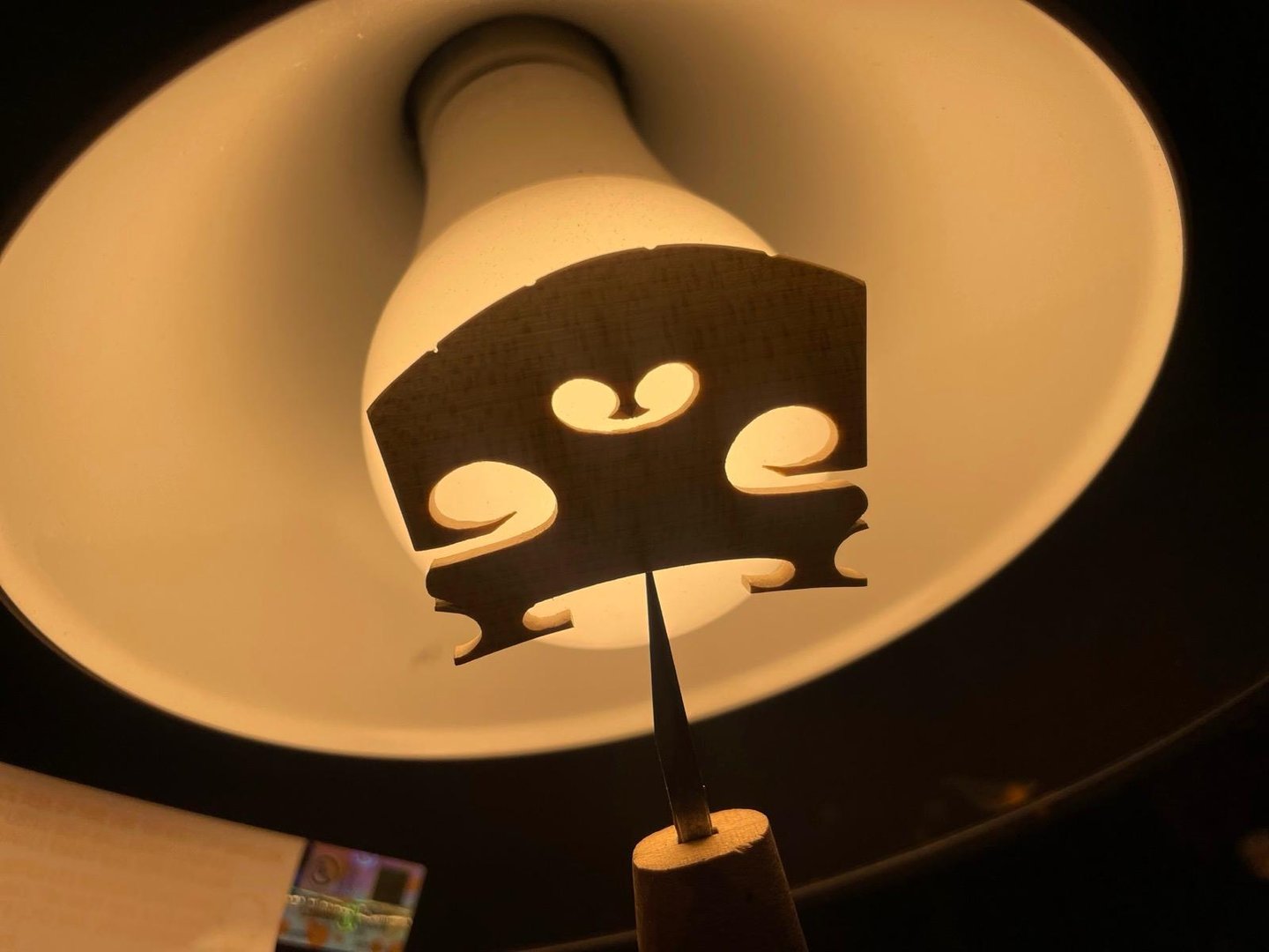 Close up of wooden string bridge for resting strings of violin or viola on white background