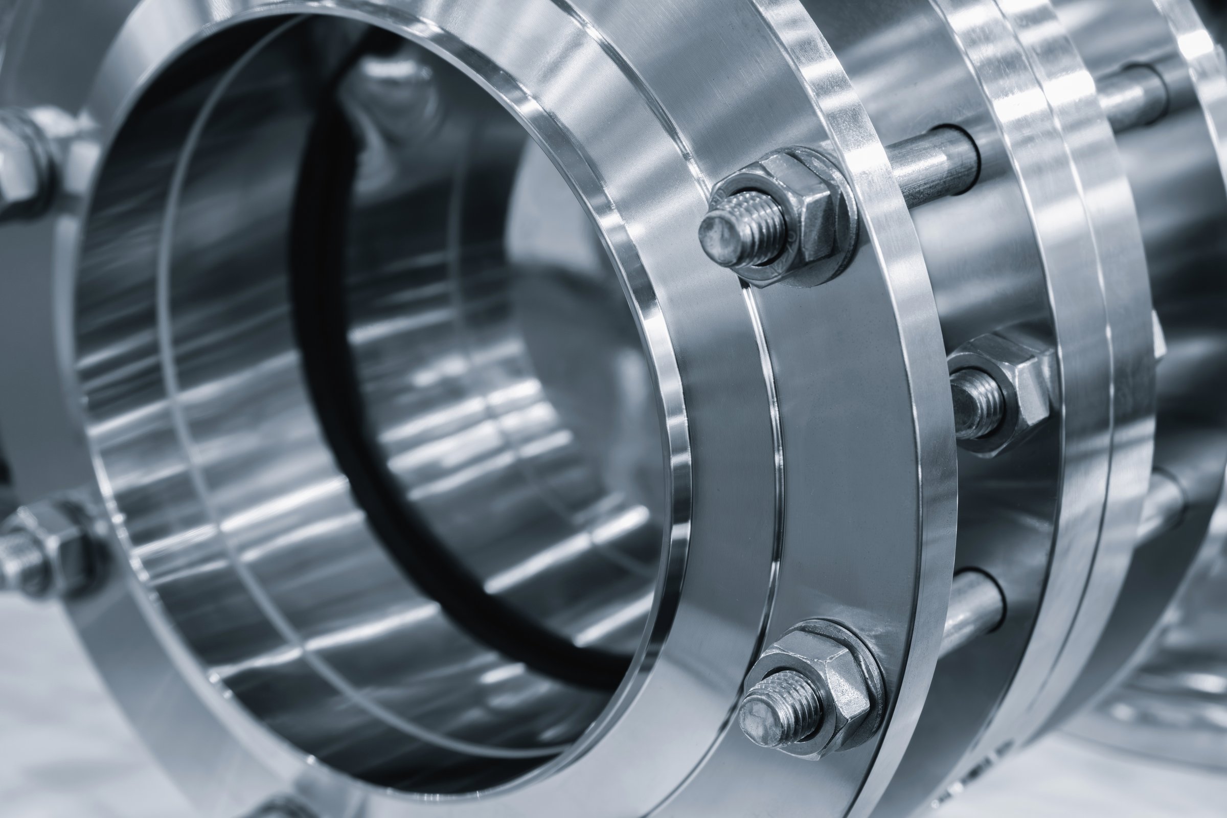 Stainless steel shiny rings connected with long bolts as part of industrial piping system, industrial concept background