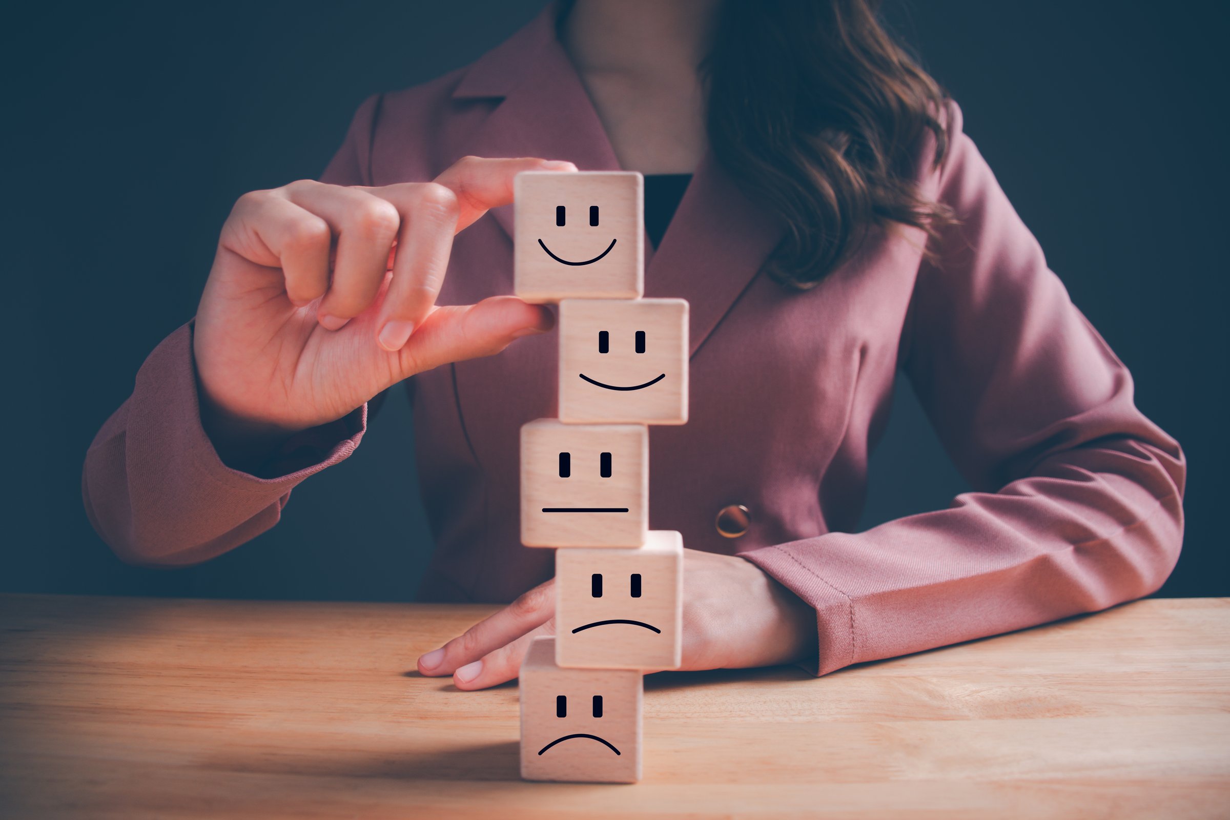 Hand picked the happy face, smile face emoticon on wooden blocks. Increase rating, Customer experience, satisfaction survey and best excellent services rating. Customer service evaluation concept.