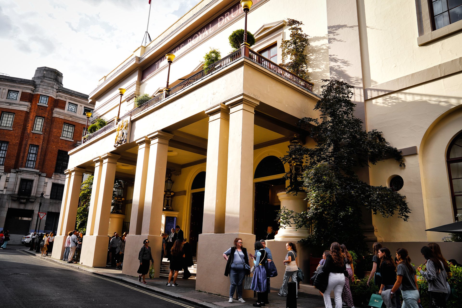 the Theatre Royal Drury Lane, Catherine St, Covent Garden in the City of Westminster, London, England - July 10, 2024 - Frozen the Musical. The street is lined with people waiting in queues for tickets to the show. the lively atmosphere, and entertainment, crowds of tourists and locals. Passersby stroll casually along the sidewalks, some stopping, at the historic theatre. London's West End.