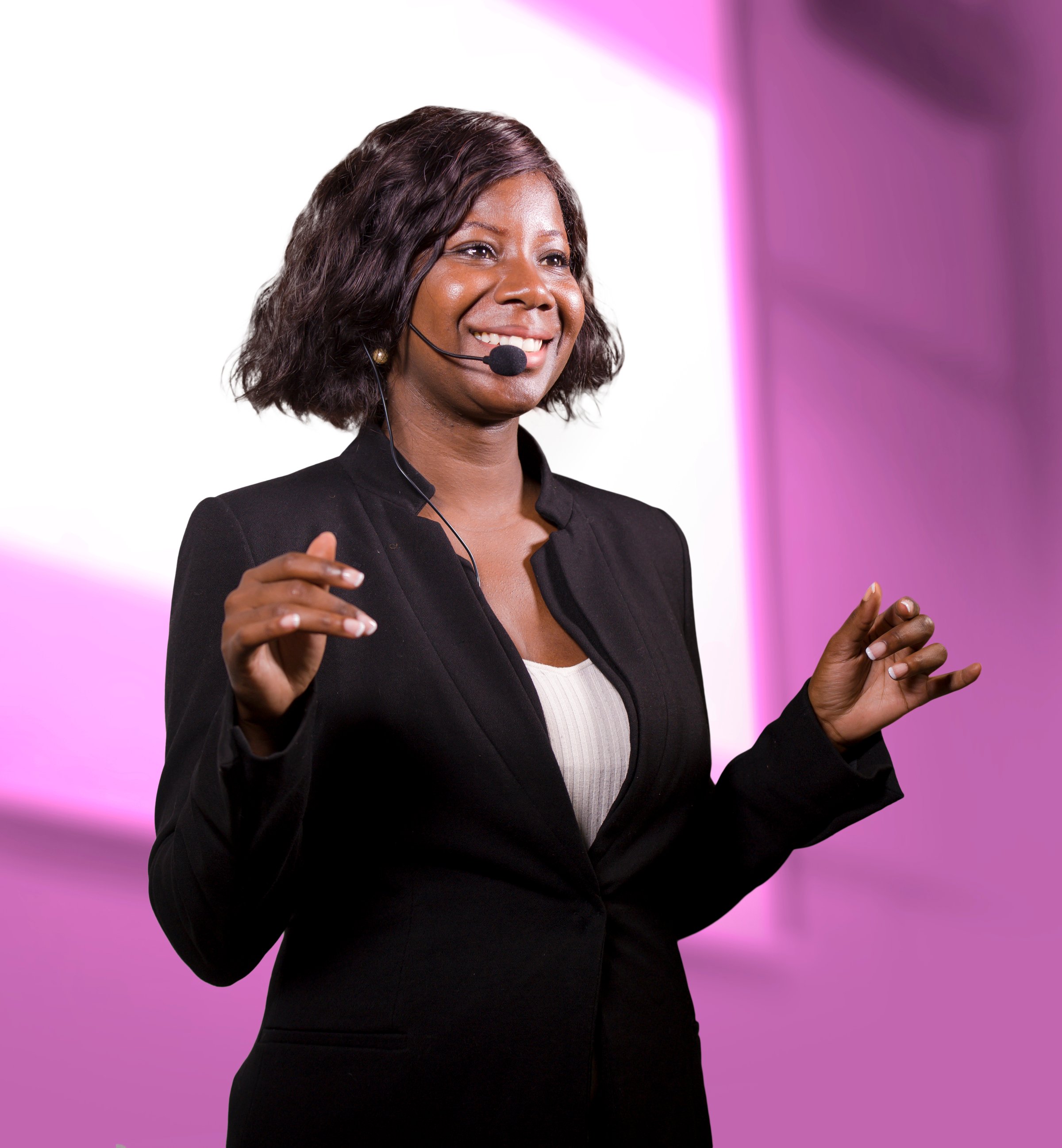 young attractive and successful black African American business woman with headset speaking in auditorium at corporate training event or seminar giving motivation and success coaching conference