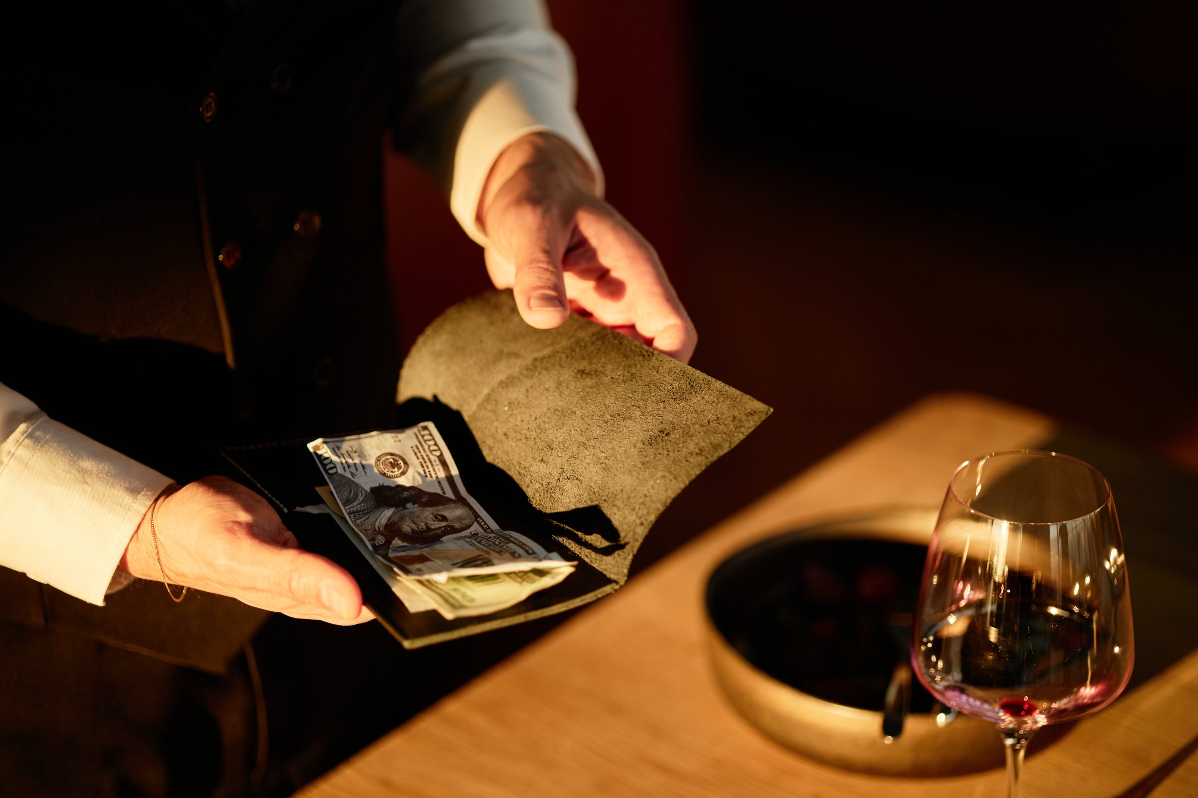 Waiter holding bill folder with cash at restaurant