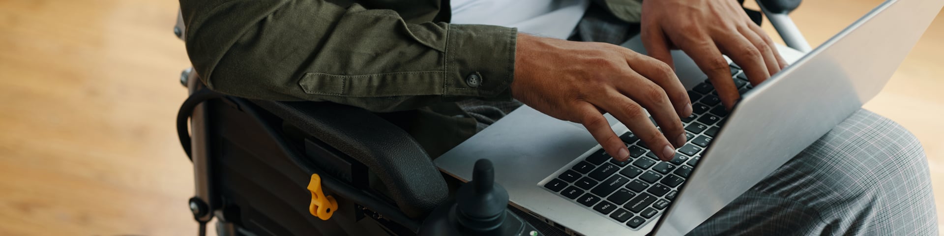 Header with man with disability typing on laptop