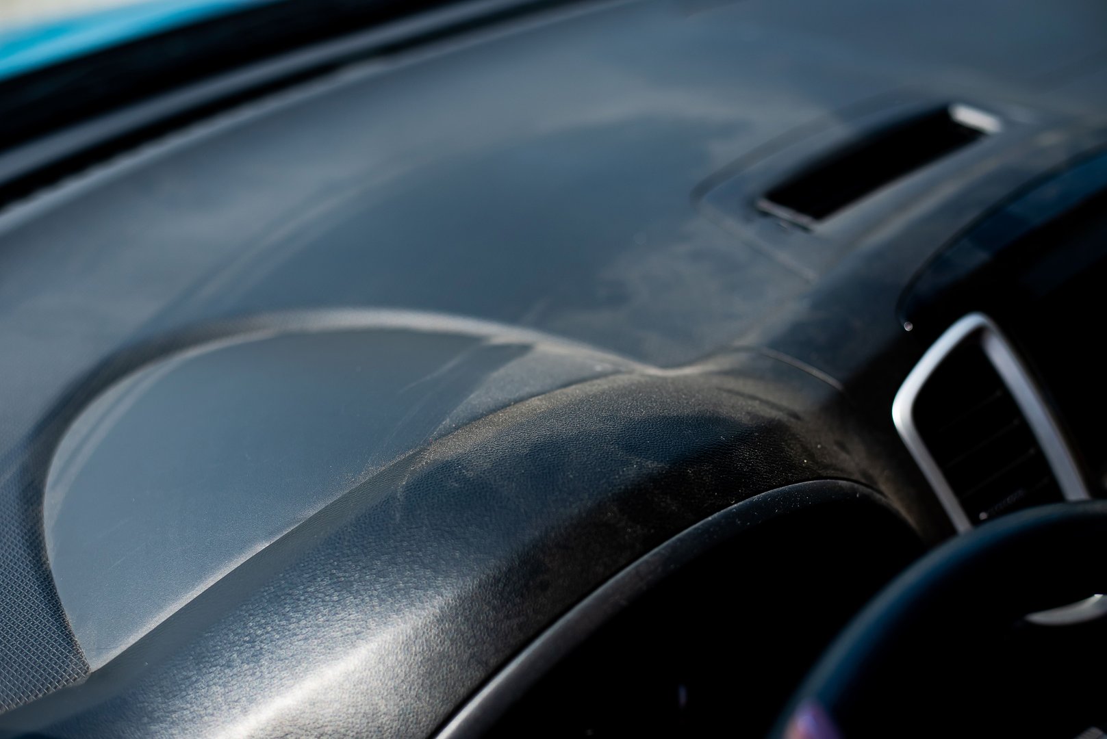 Thick layer of dust on the plastic car dashboard