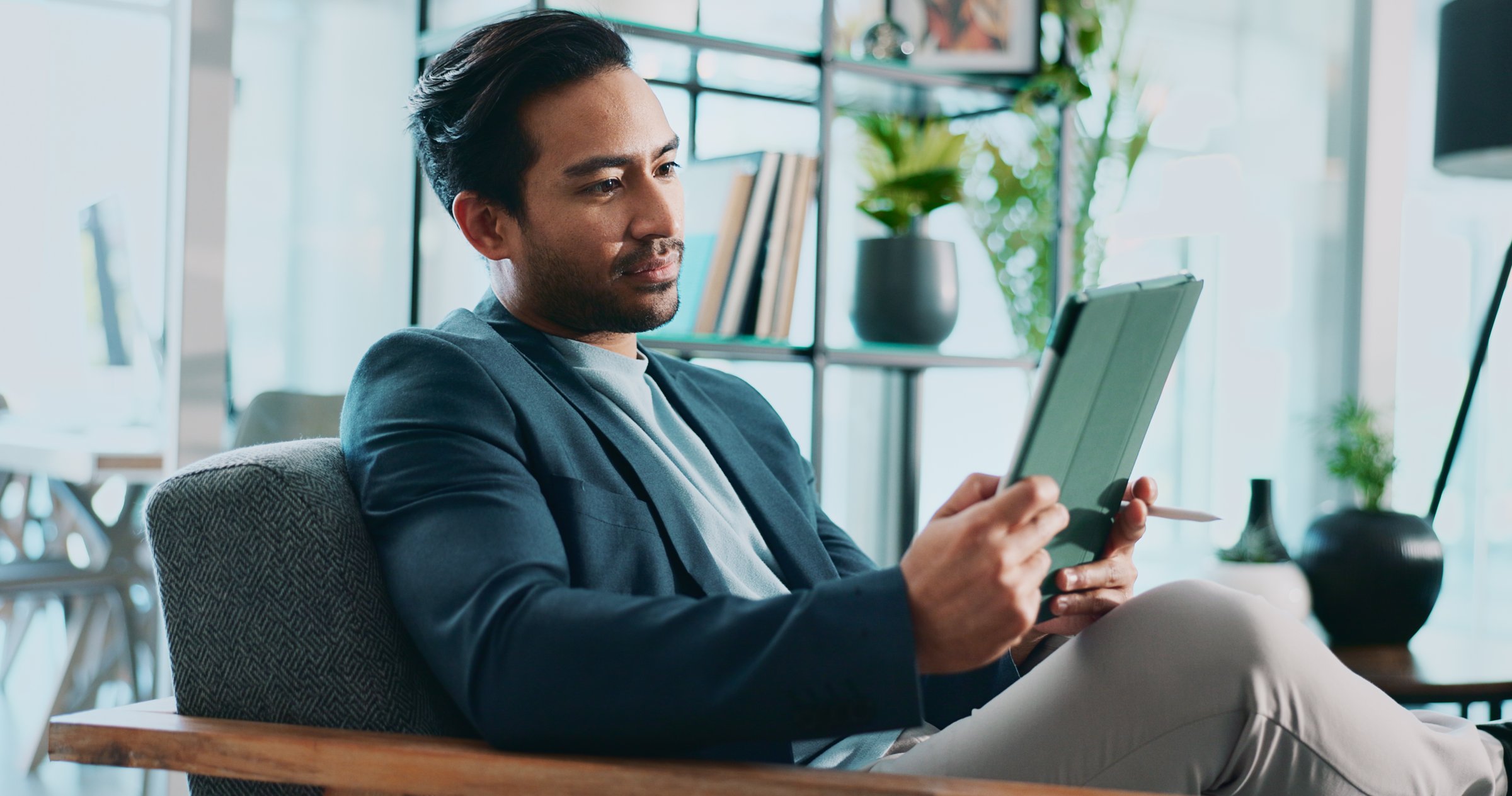 Businessman, tablet and reading in office for news, economy update and website for research. Trader, tech and relax in workplace with cryptocurrency app, finance management and information report