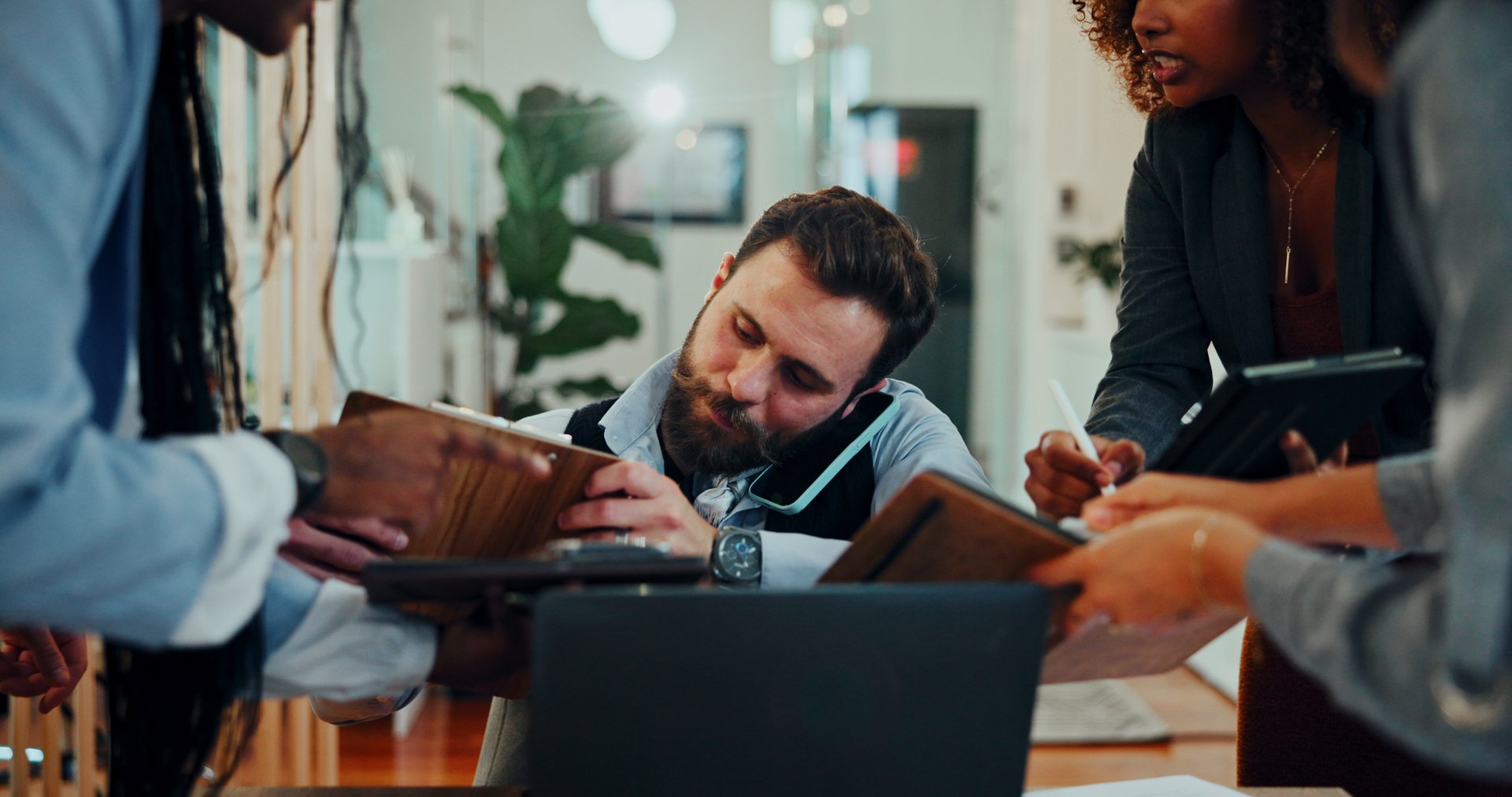 Phone call, overworked and signature with business man in office for deadline, chaos and project management. Teamwork, overwhelmed and stress with people in agency for overtime, frustrated or burnout