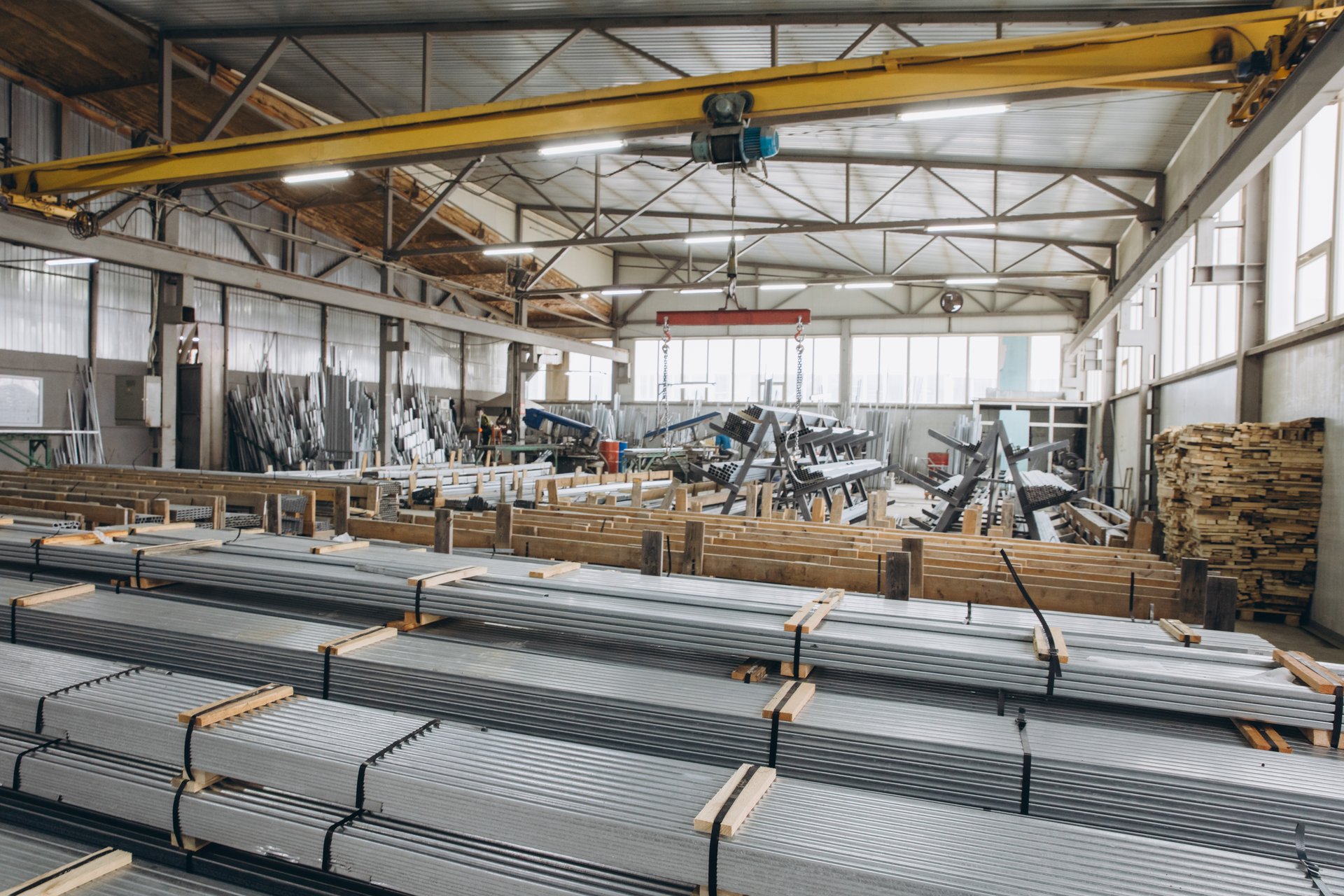 Aluminum profiles are stacked and stored in a large warehouse ready for windows and doors production
