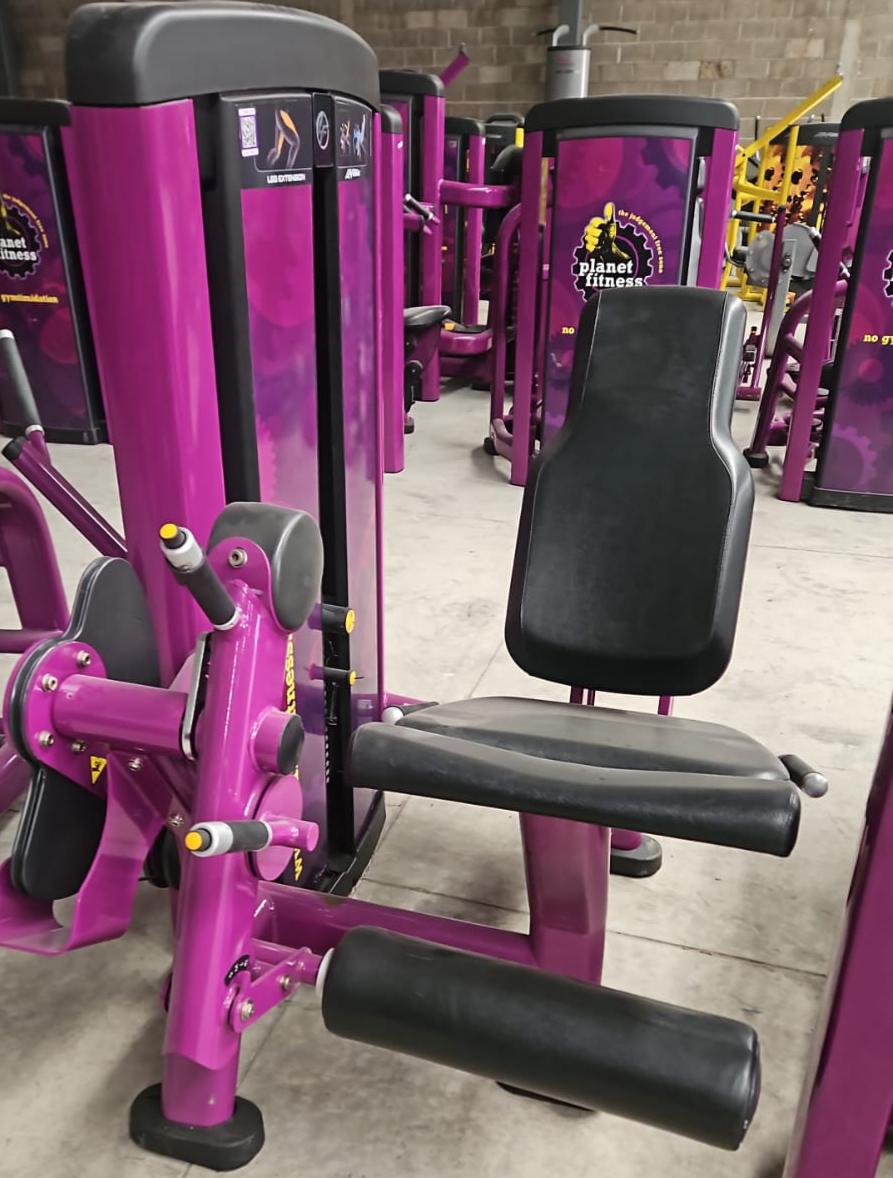 Purple leg exercise machine at Planet Fitness gym with padded seat and backrest.