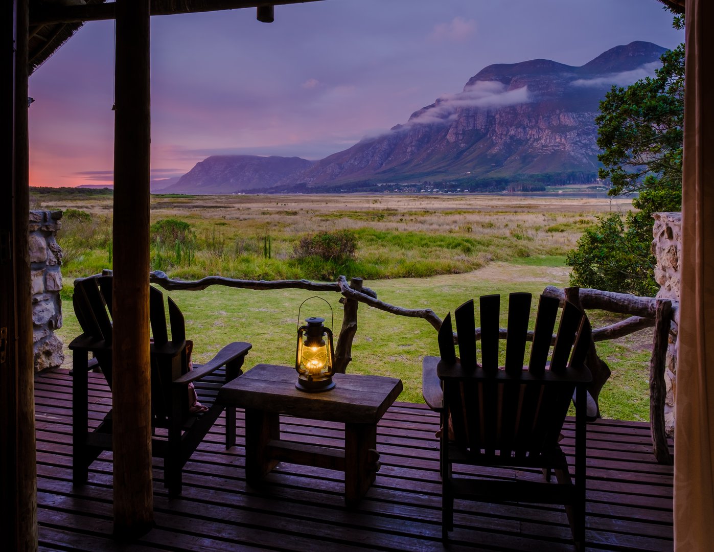 Mountains and grassland near Hermanus at the Garden Route Western Cape South Africa Whale coast. A lodge wooden bungalow with chairs during a vacation in South Africa at Susnet