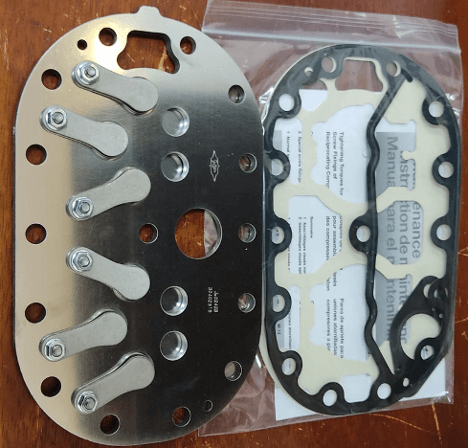 Metal flange with gaskets on a table, showing components for sealing or mechanical assembly.