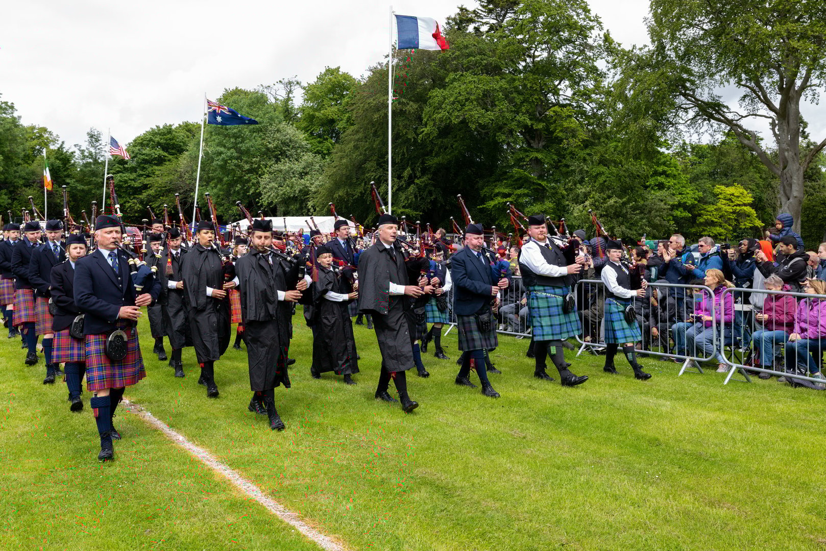 Massed Pipe Bands on the arena circuit at the Aberdeen Highland Games
