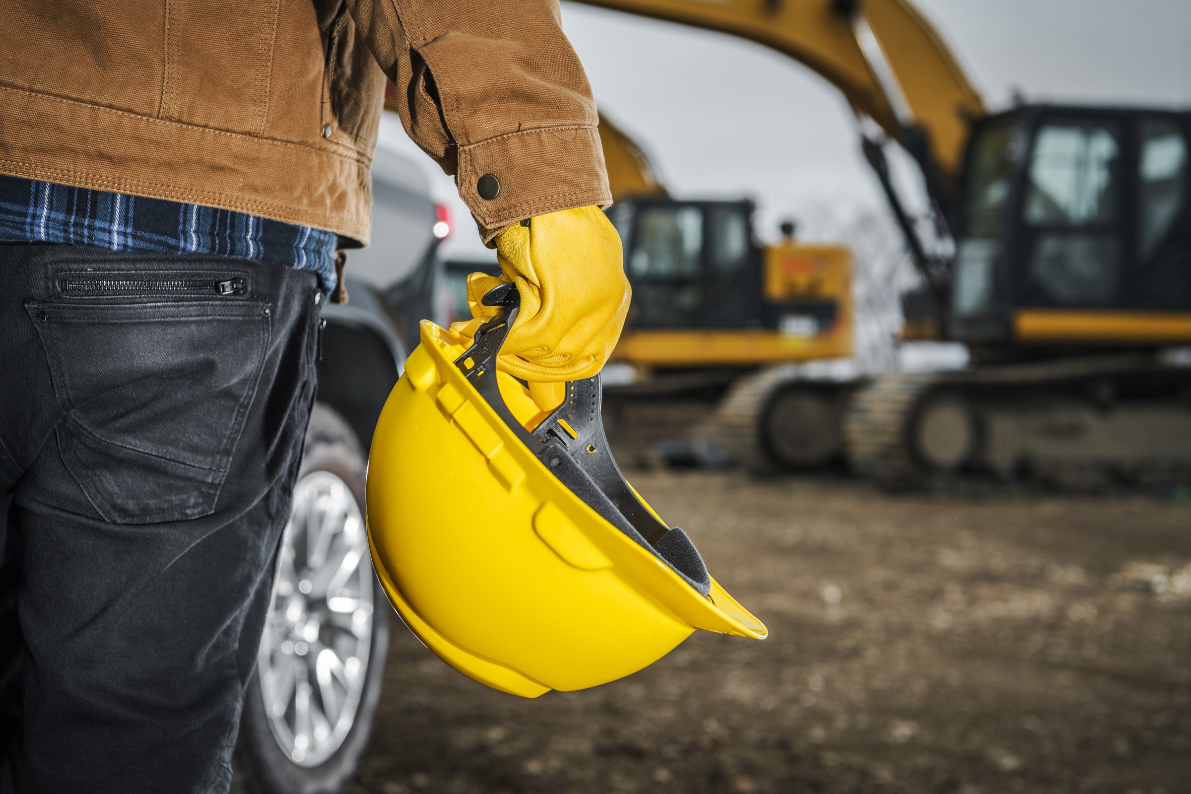 Head Safety Construction Zone. Contractor Worker with Yellow Hard in His Hand. Construction Industry Theme.