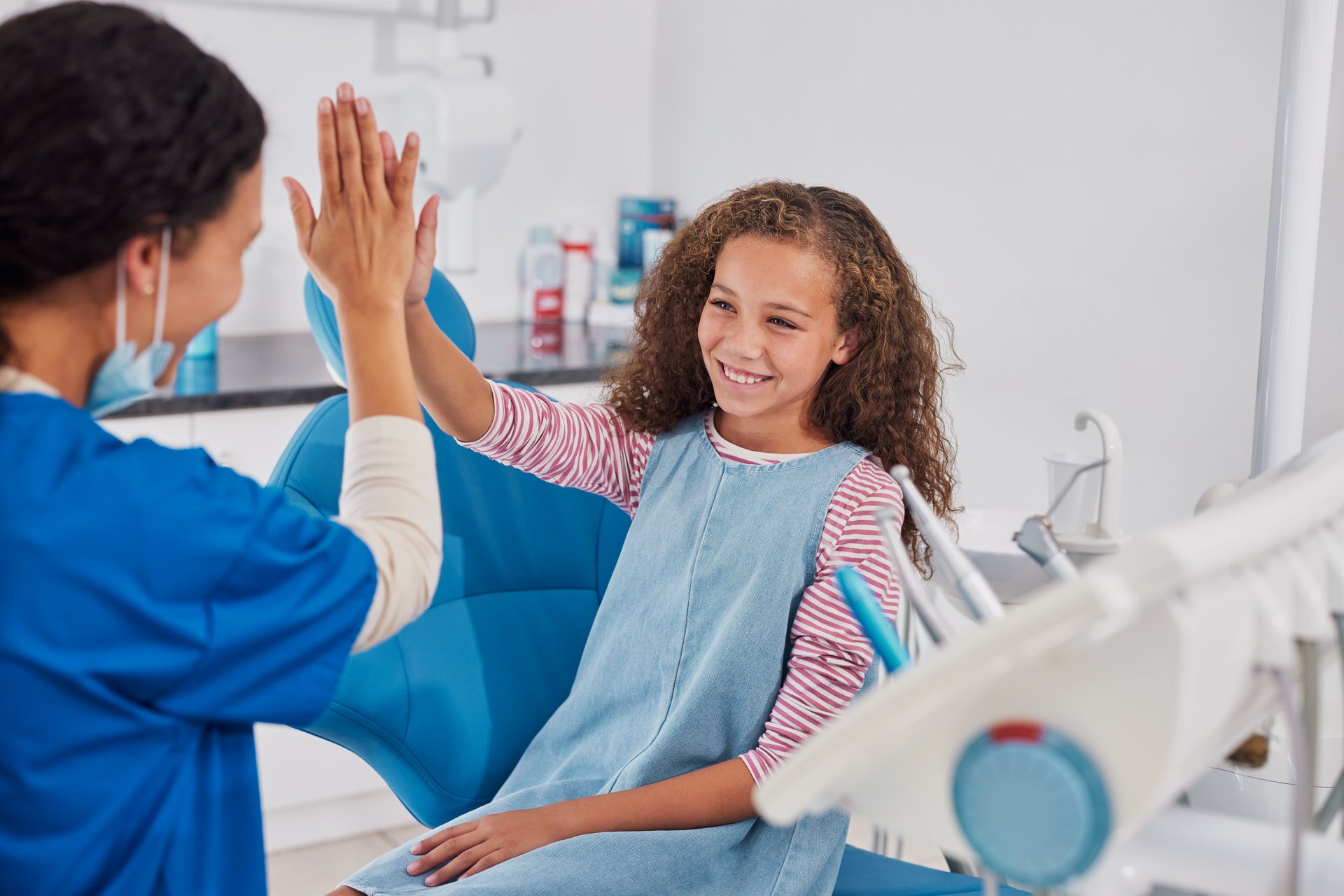Happy girl giving high five to dentist