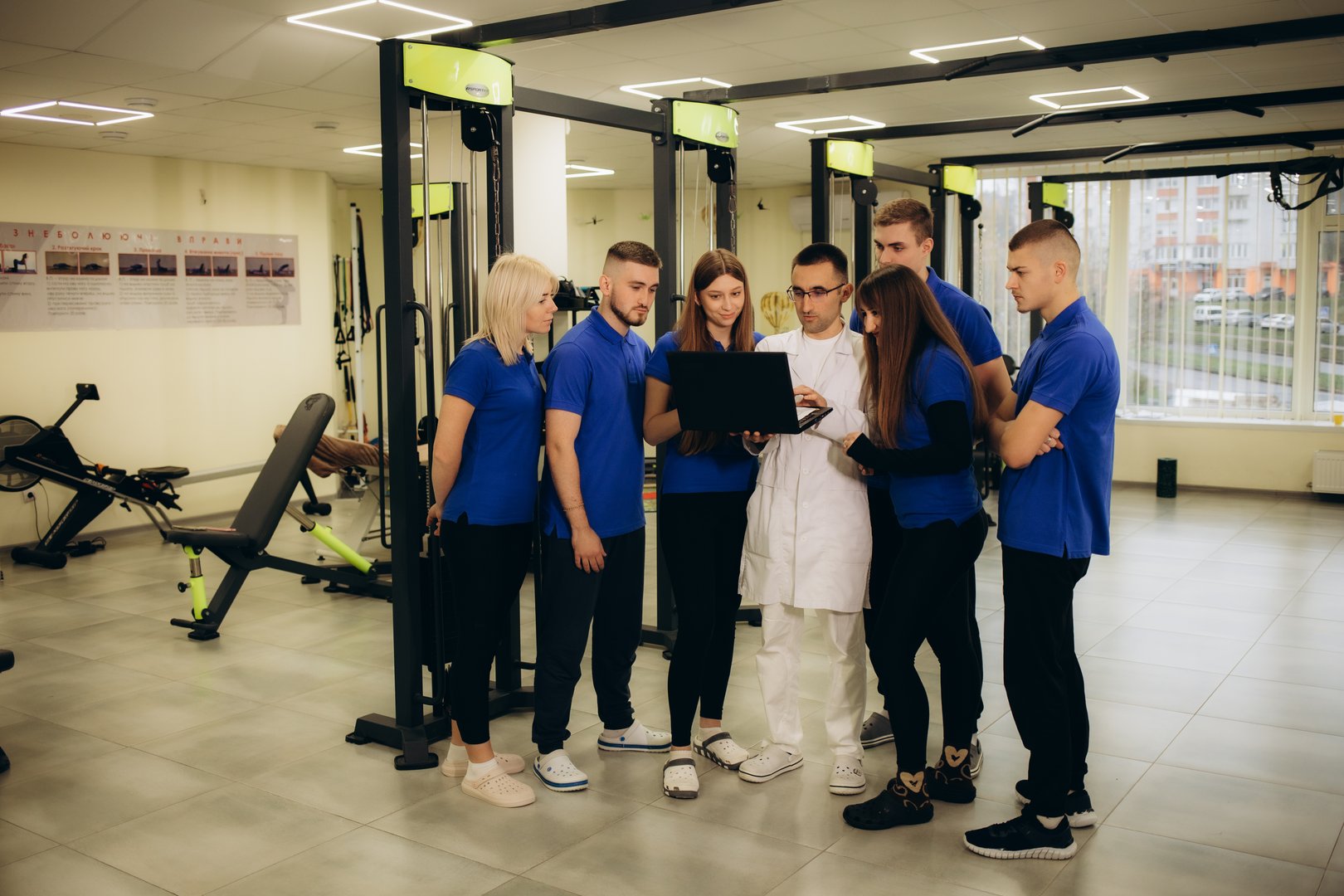 a group of physiotherapists look at a tablet in a rehabilitation center