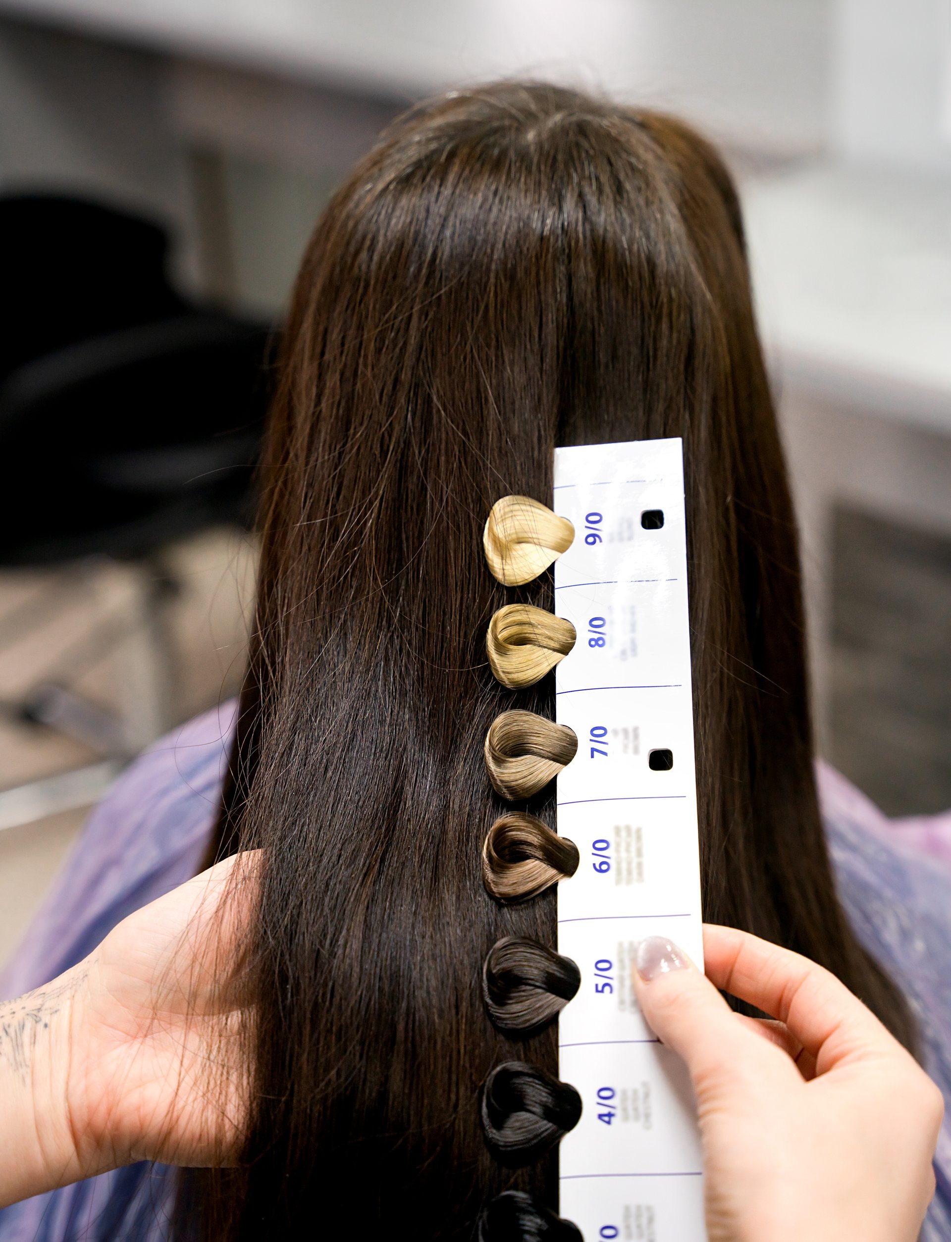Professional hairdresser selects hair colour for the client. Beauty salon, hair care. Close-up. Selective focus.