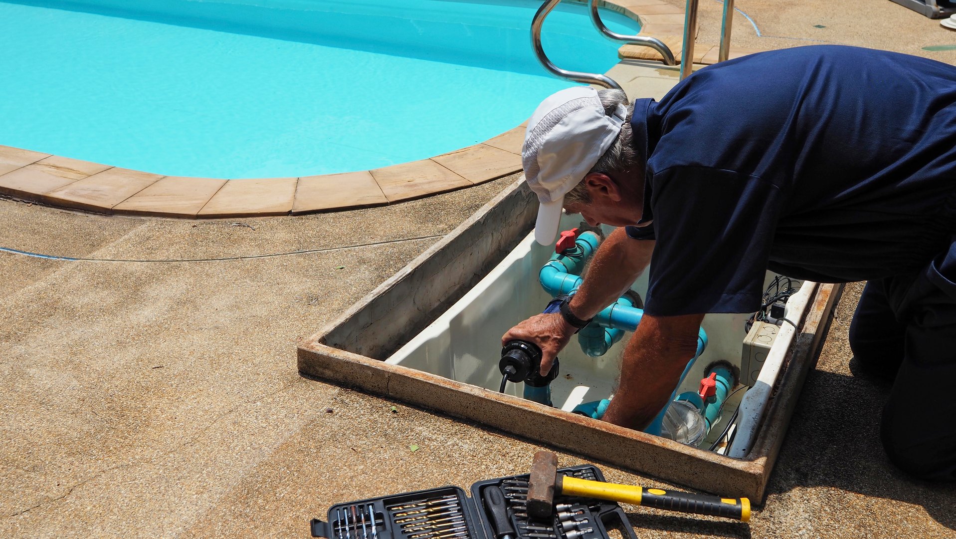 Technician fixing swimming pool water pump. Service and maintenance for swimming pool.