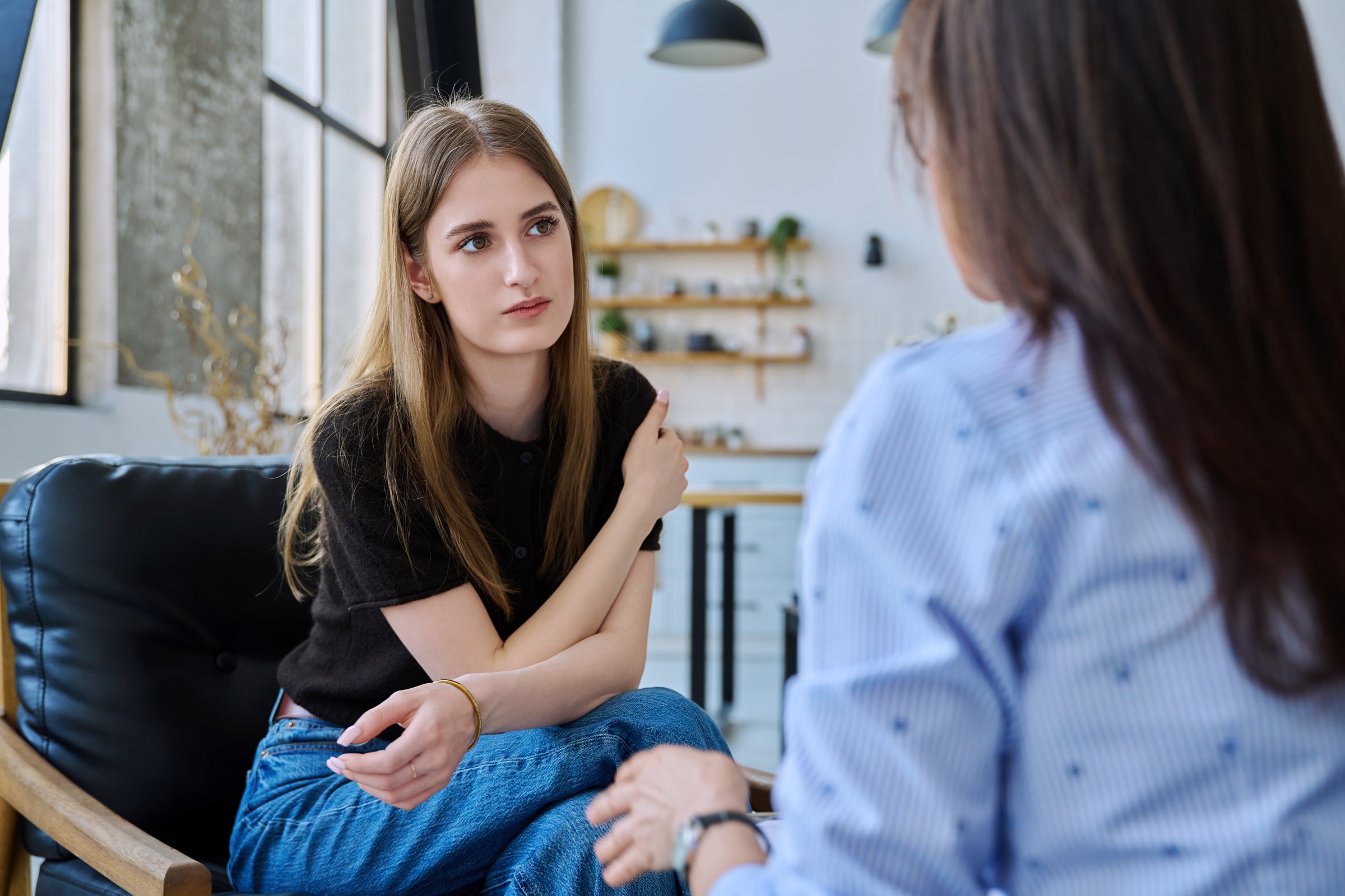 Young woman talking to social worker, home meeting, home visit of psychological counselor, survey consultation. Social services, psychology psychotherapy help treatment support, mental health, youth