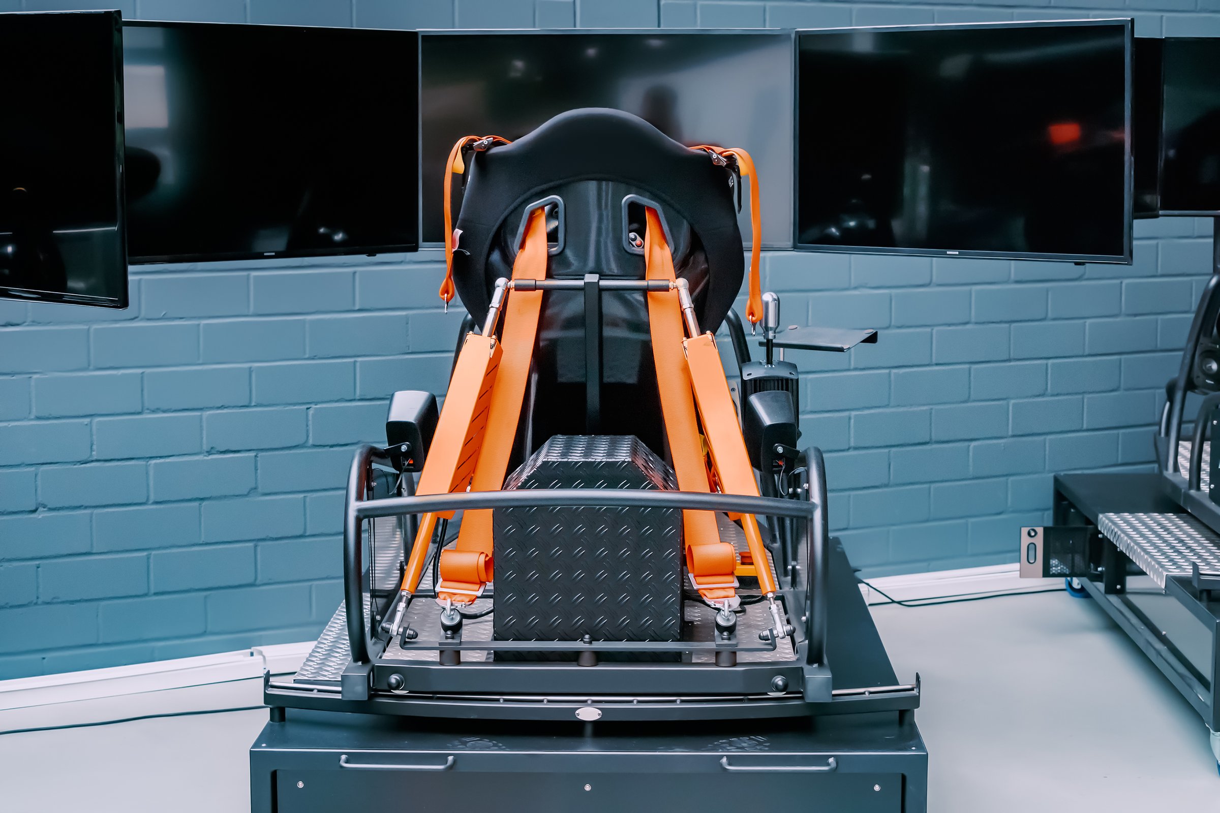 Professional simulator and trainer of a racing driver with a chair with levers and multiple monitors