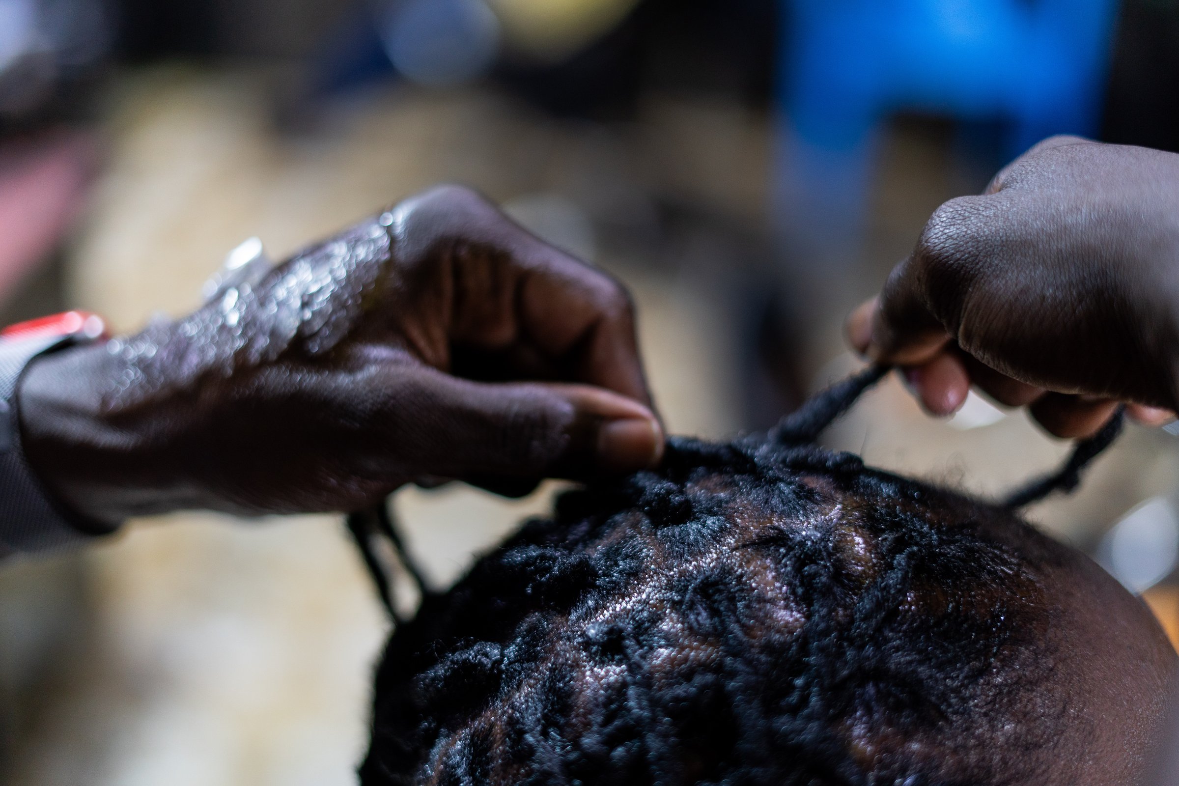 A closeup shot of a dreadlocks being retouched.