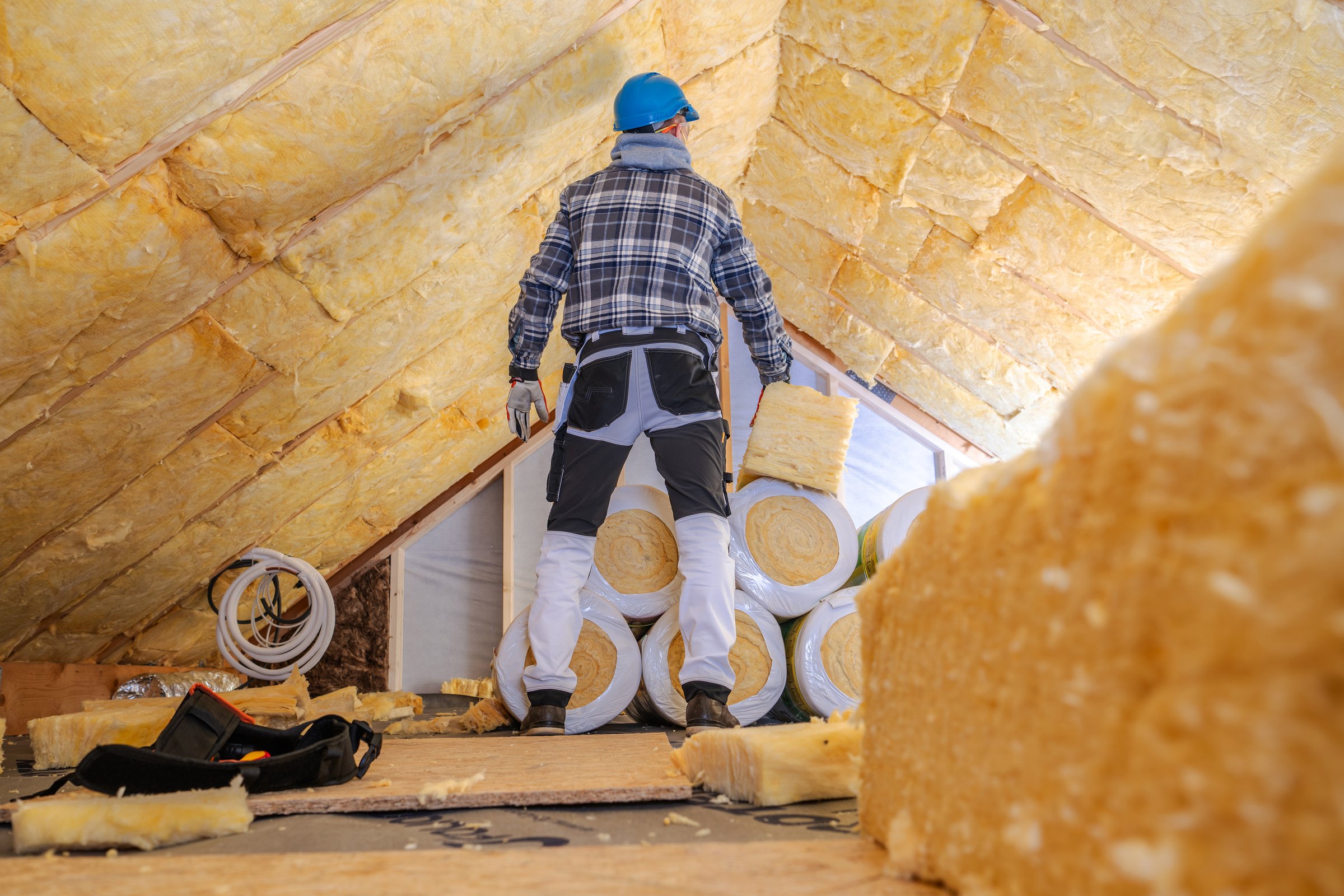 Worker inspecting attic insulation
