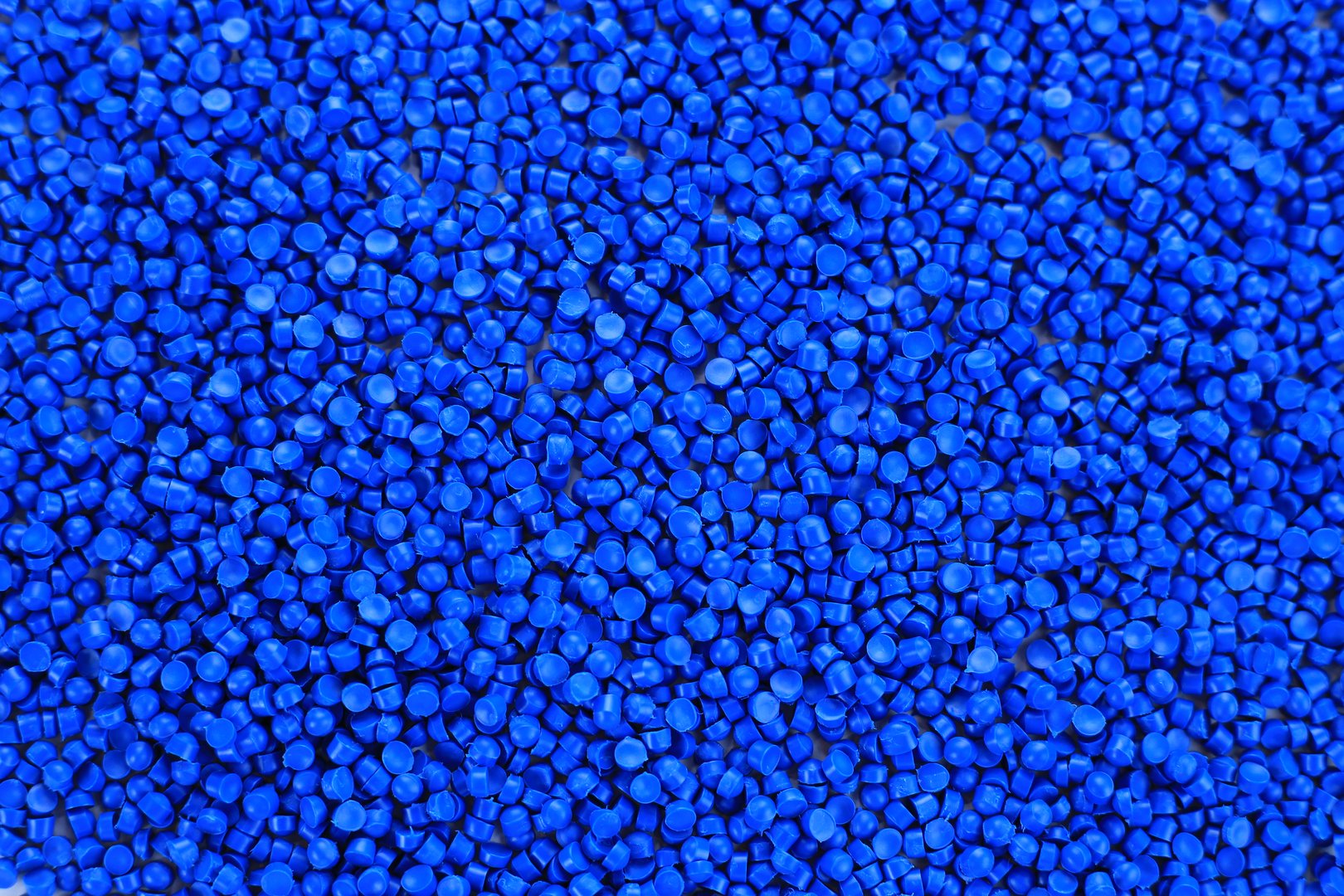 Close-up of blue plastic polymer granules. polymer plastic. compound polymer. PVC resin compounds. Tinted plastic granulate for injection moulding process.