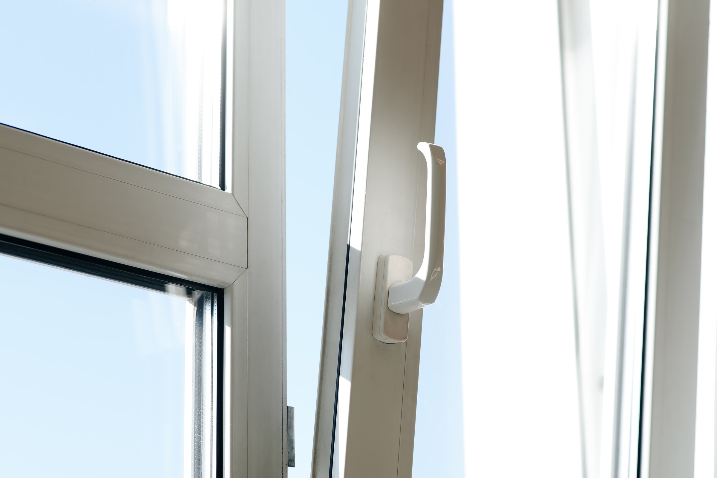 open plastic window in apartment or office, partially open window at angle, double glazing, sun beams, sunny day