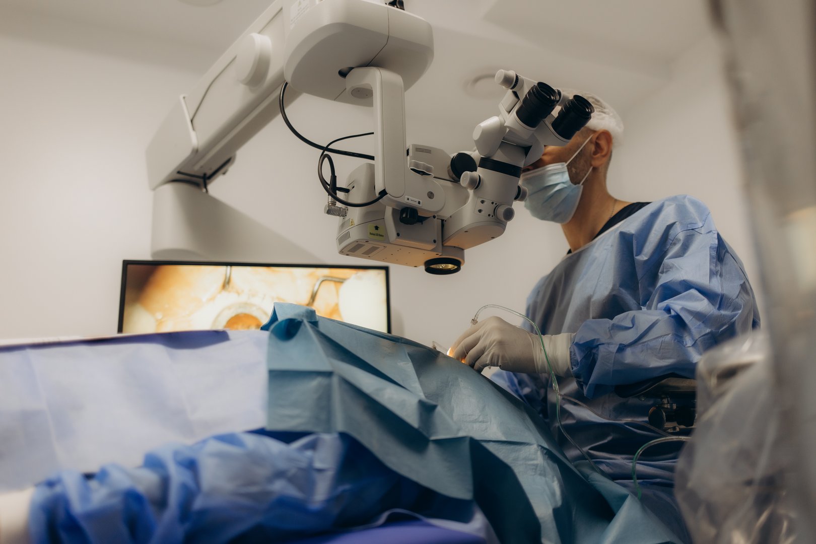 A surgeon looks through a microscope in the operating room. A doctor uses a microscope during eye surgery or diagnosis, cataract treatment and diopter correction.