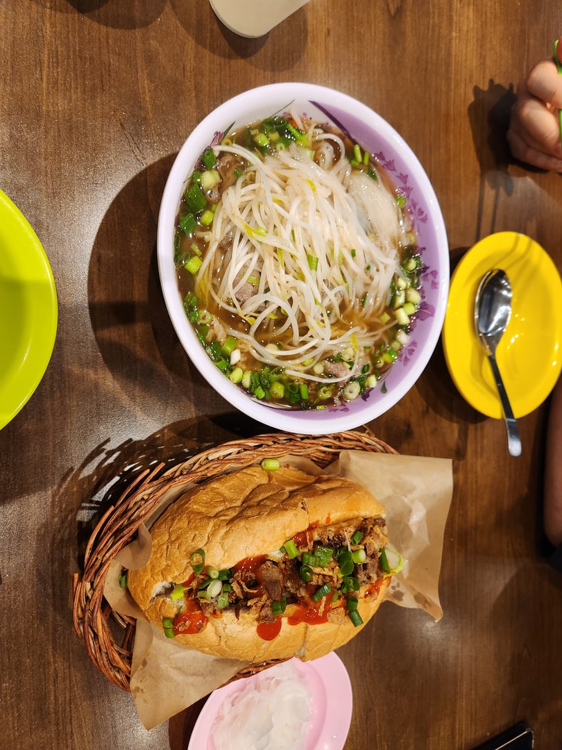 Vietnamese noodle soup and sandwich with pickled onion at a restaurant