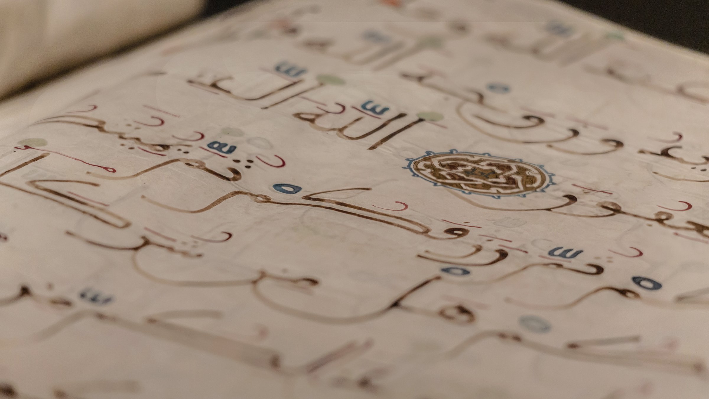 Medieval open book manuscript (verses of Koran Book, Holy Islamic Text). XII-XIV c. arabic book. Shallow depth, name of God (Allah) in focus. Copy space, grunge background. Istanbul, Turkiye