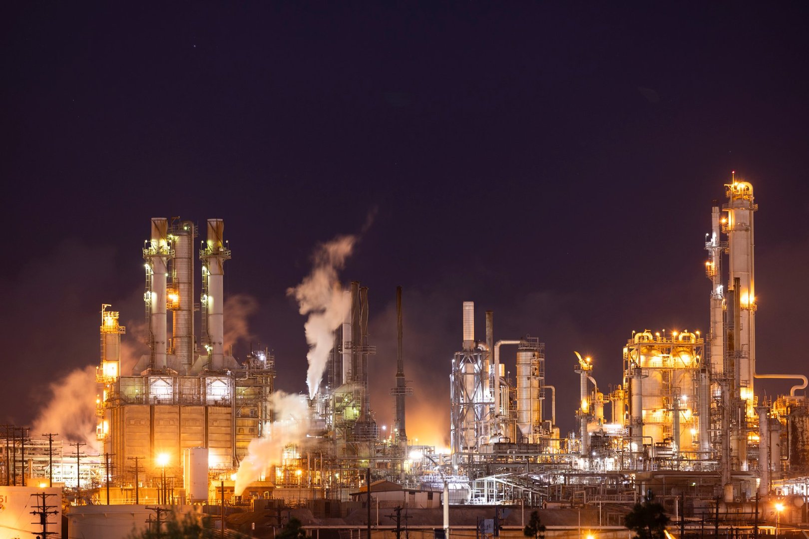 Wilmington, California, USA - July 16, 2021: A Phillips 66 refinery releases carbon dioxide exhaust as the by-product of gasoline production at night.